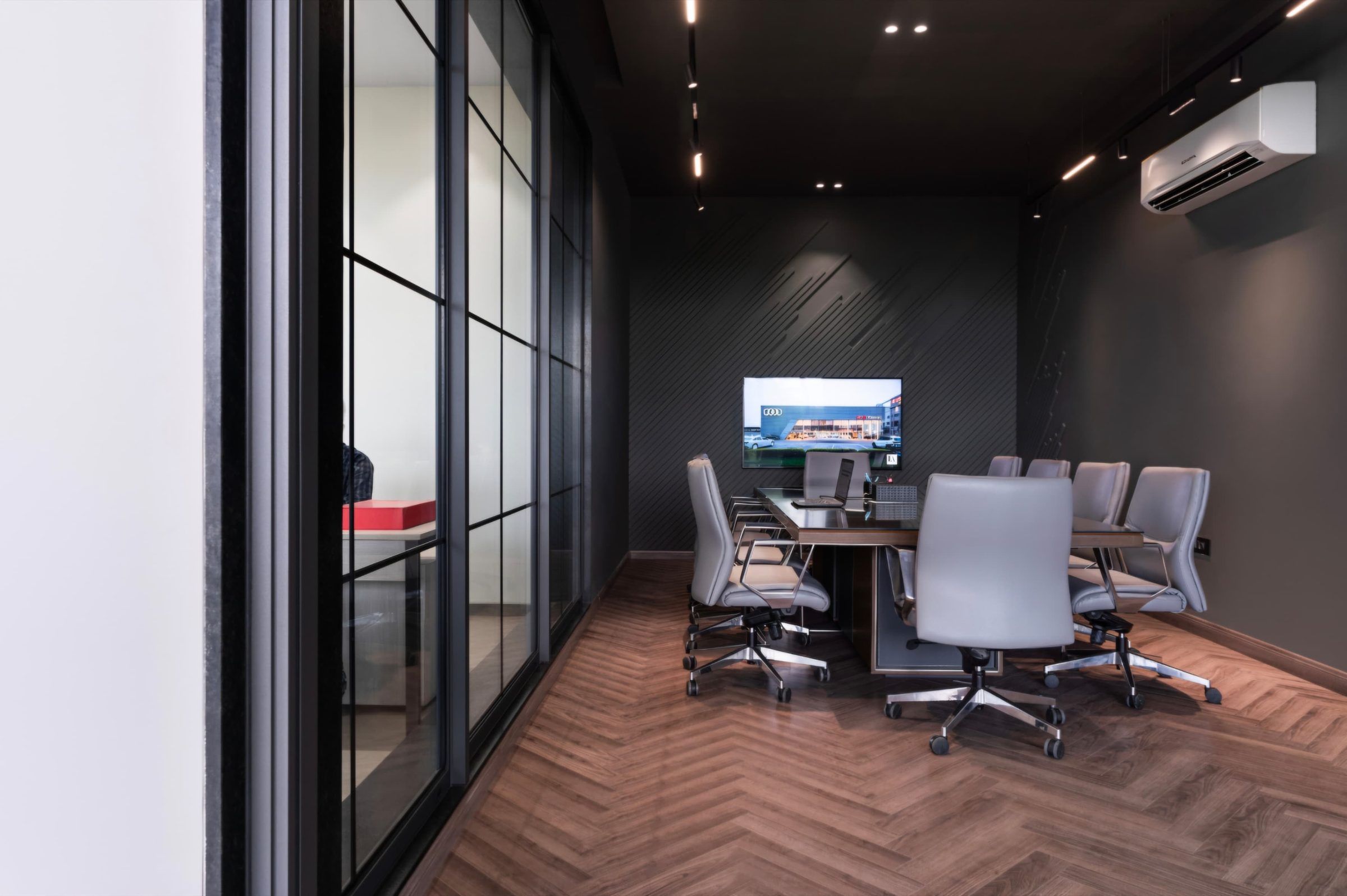 Meeting room enclosed by black-framed glazing