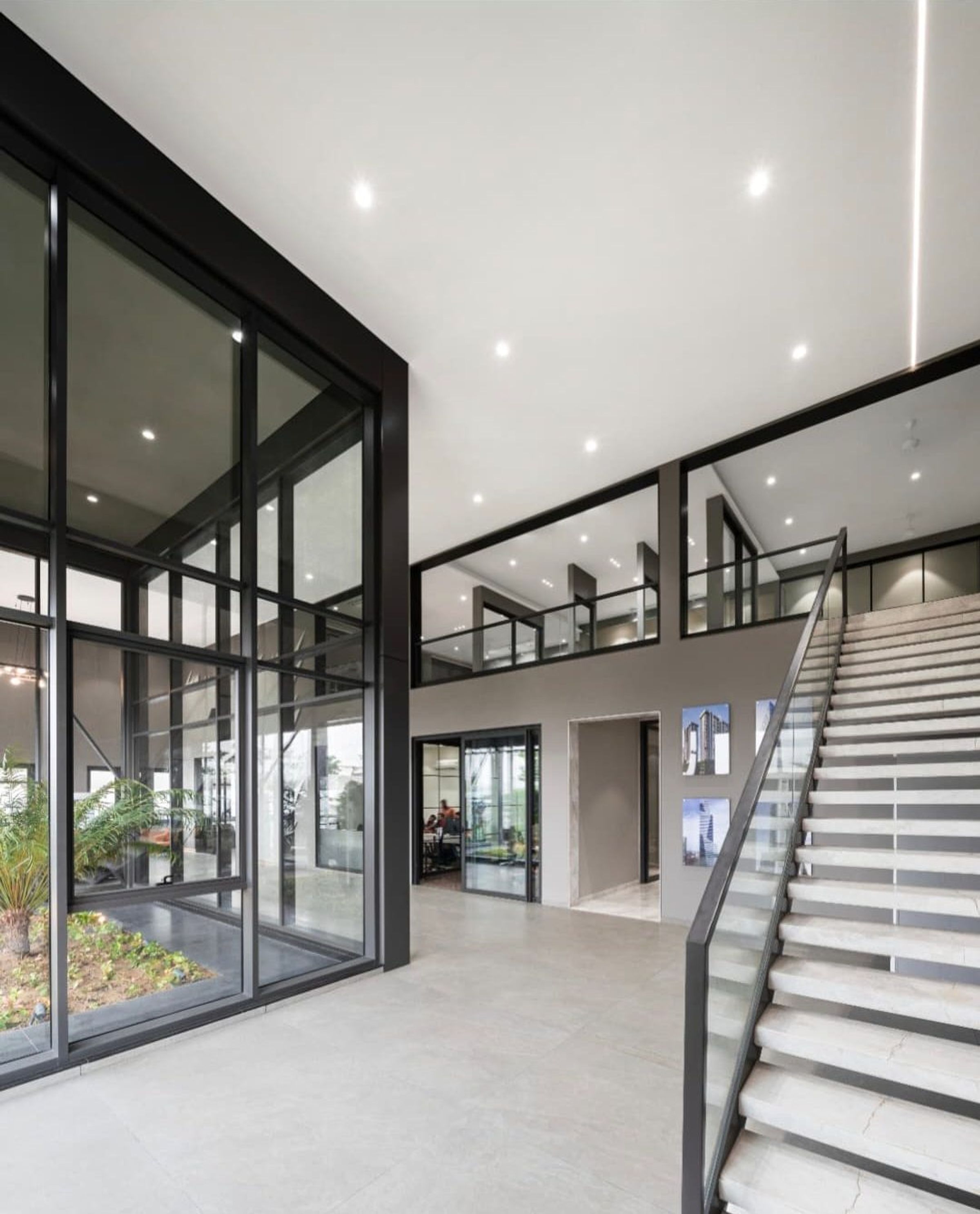 Double-height hall with glazed partitions and a staircase