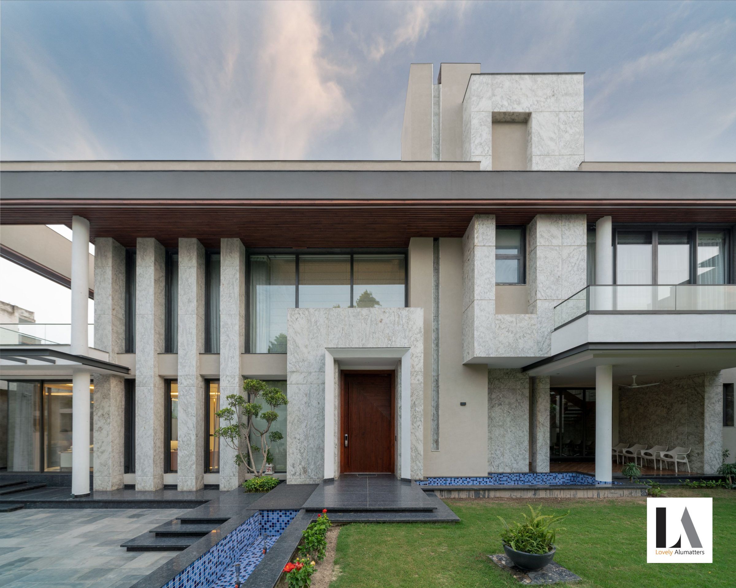 Stone villa entrance with tall columns and wide glazing on both floors
