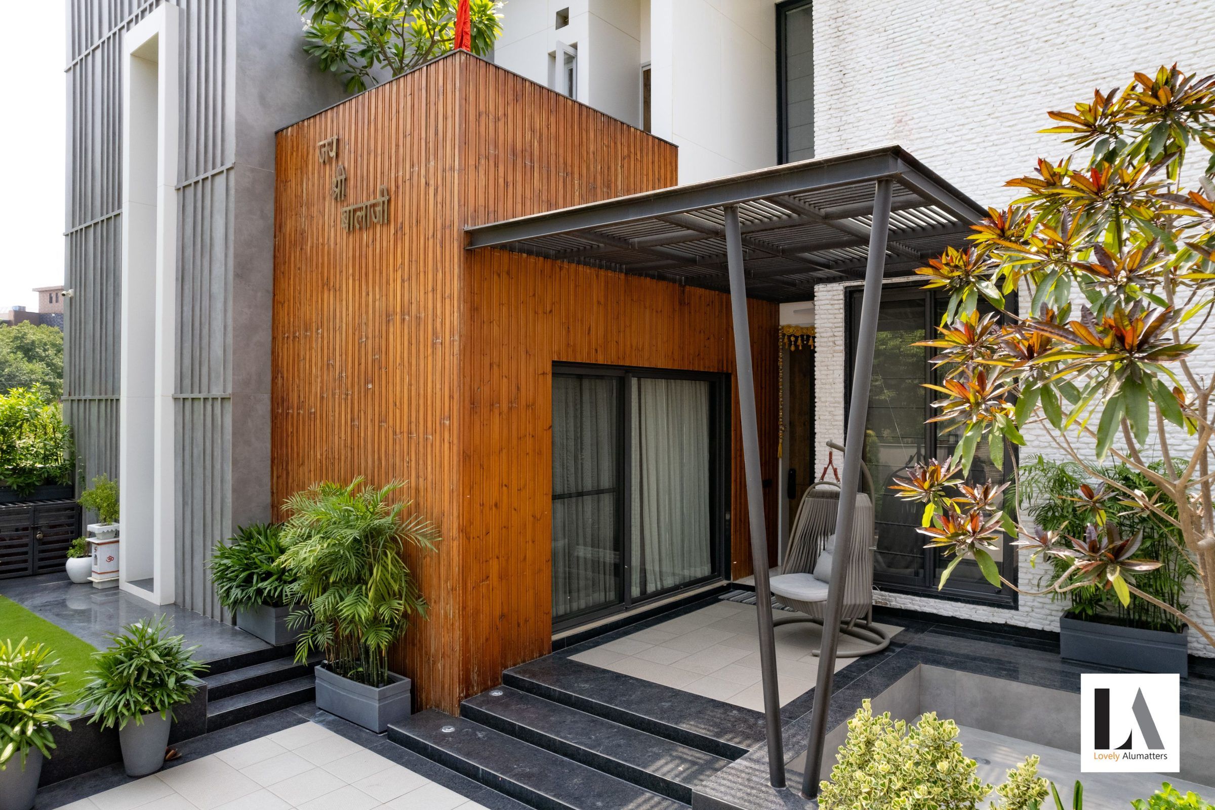 Timber-clad entrance pavilion with sliding glass doors and a steel canopy