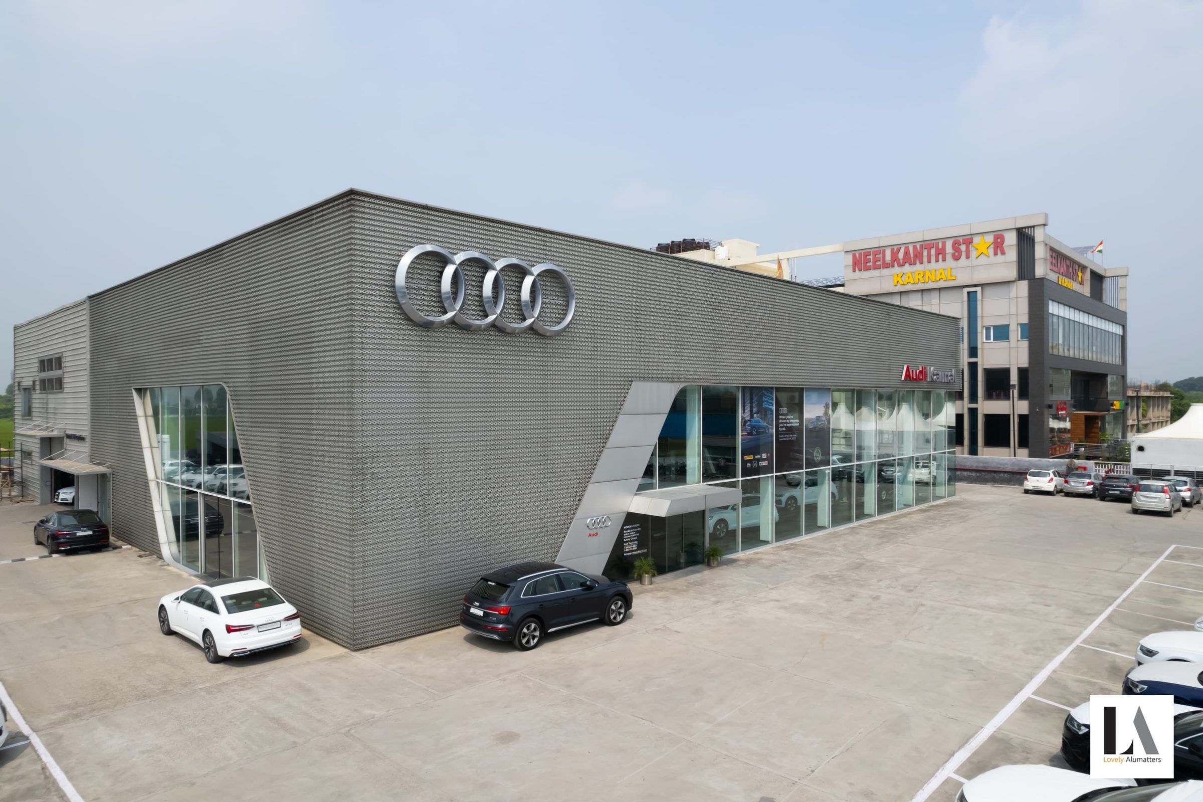 Showroom exterior with glazed corners set into an angled metal façade