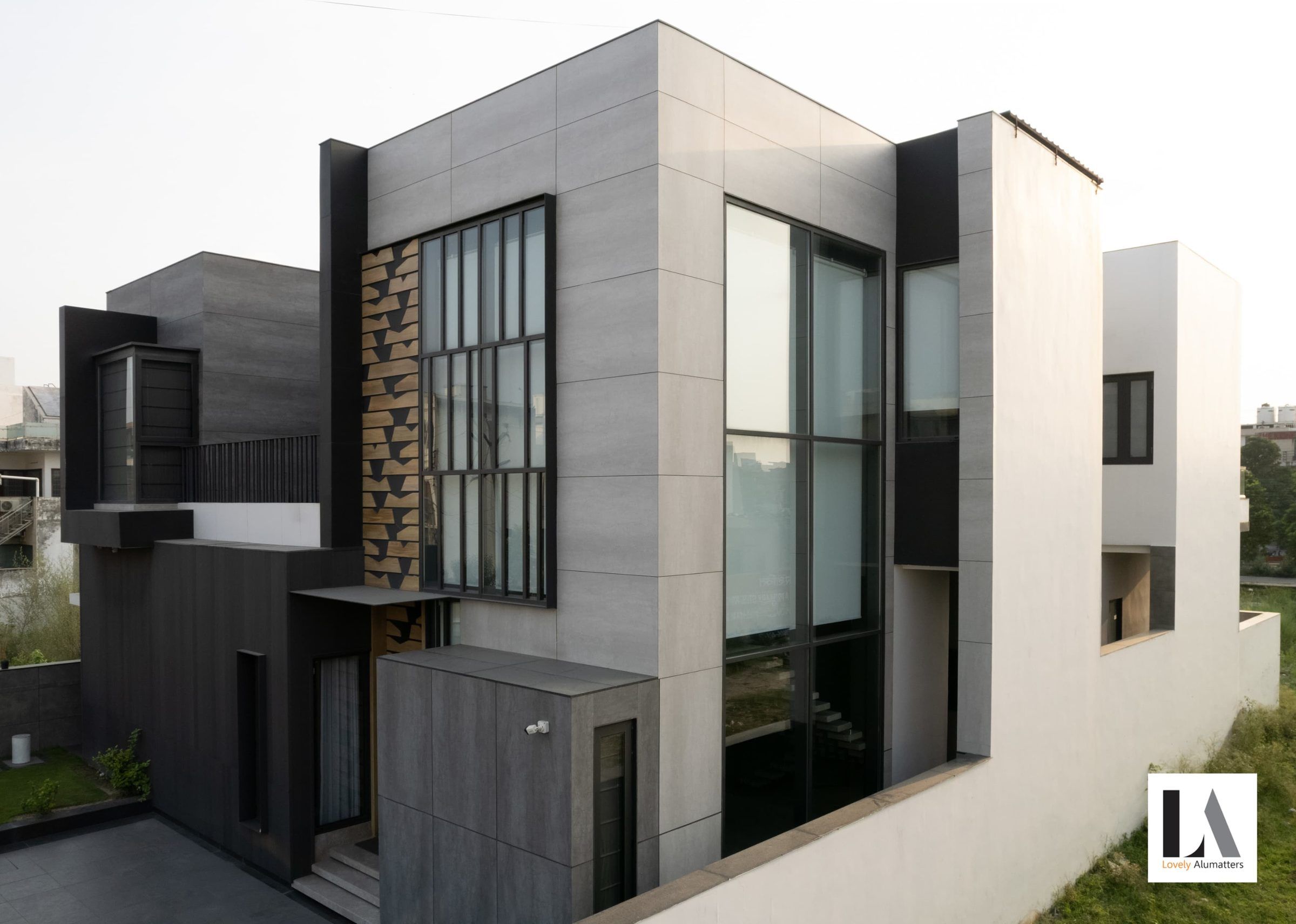 Layered grey façade with vertical window bands and a patterned stone panel
