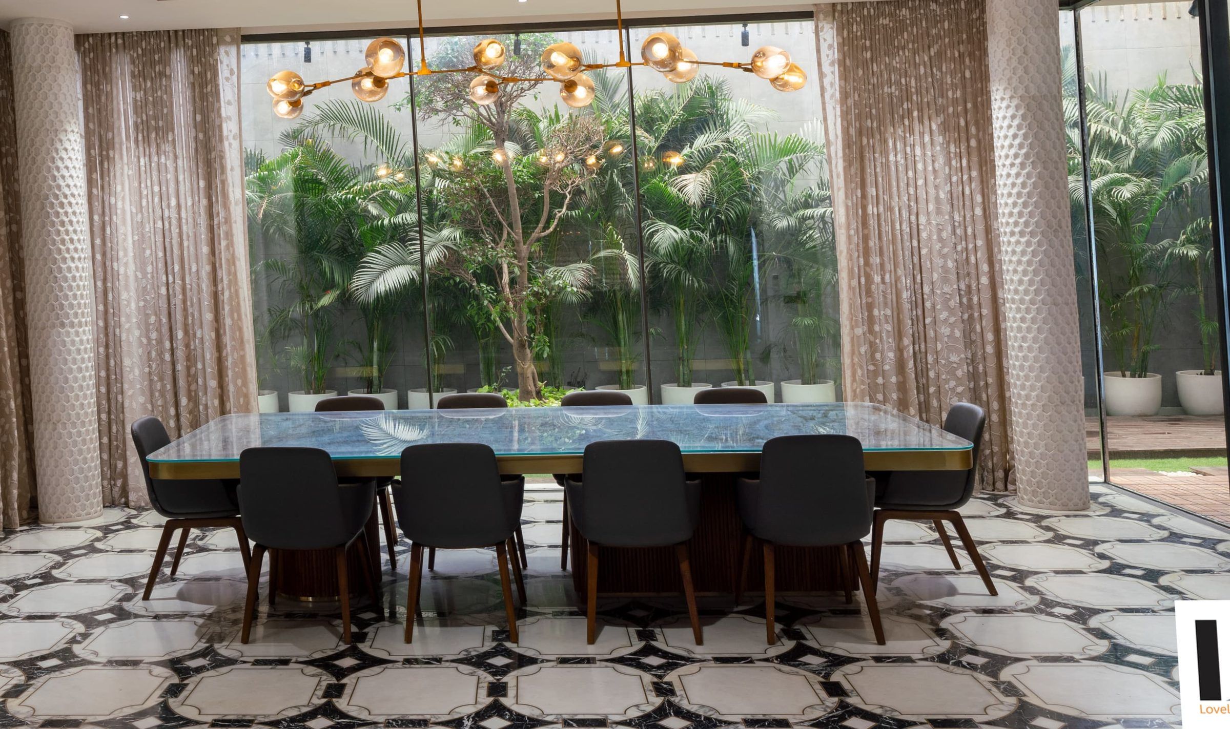 Dining room behind full-height glazing looking onto a landscaped courtyard