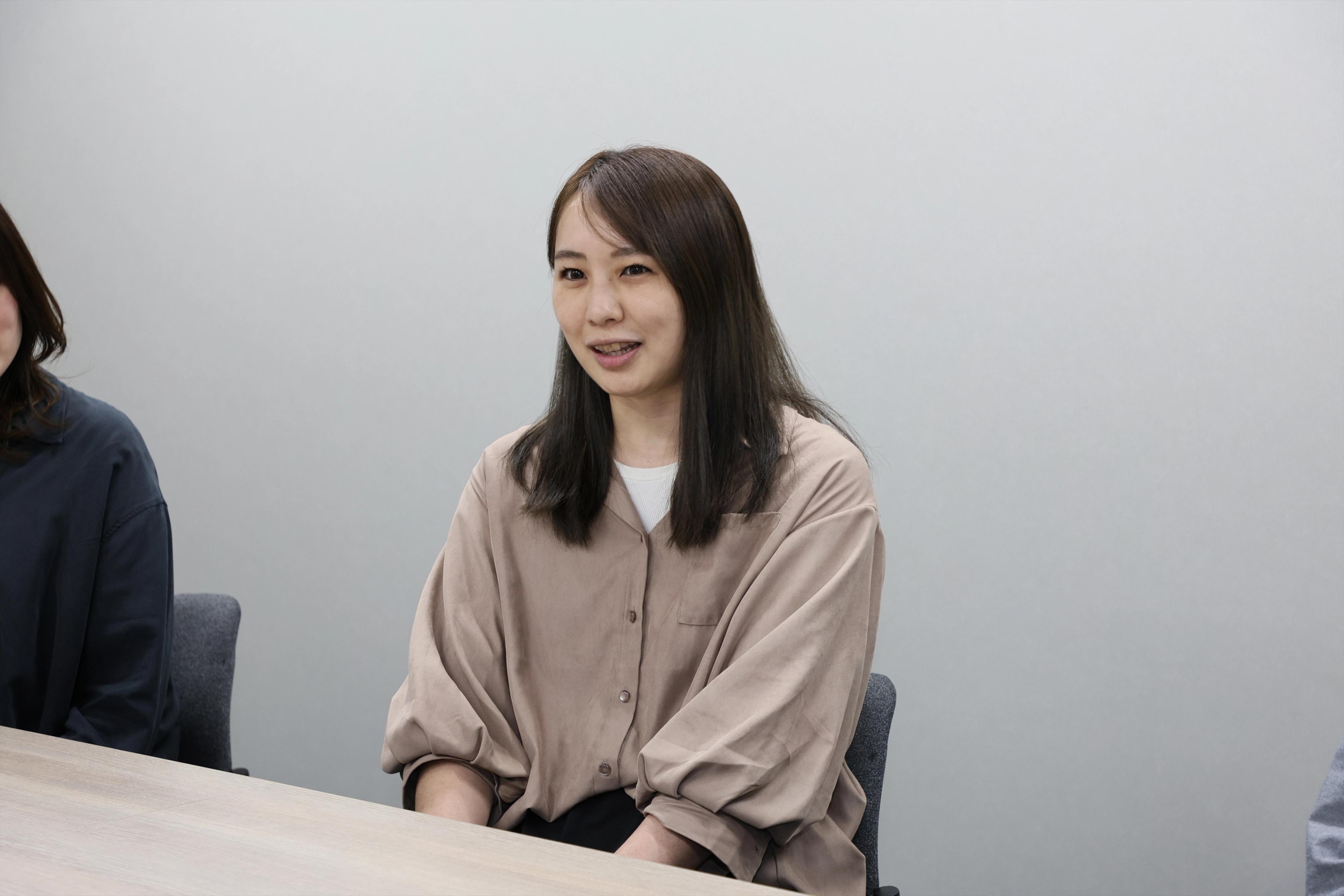 OMO本部マーケティング部 吉野 有香氏がインタビューを受けている様子。茶色のシャツをきていて前に笑顔で話をしている

