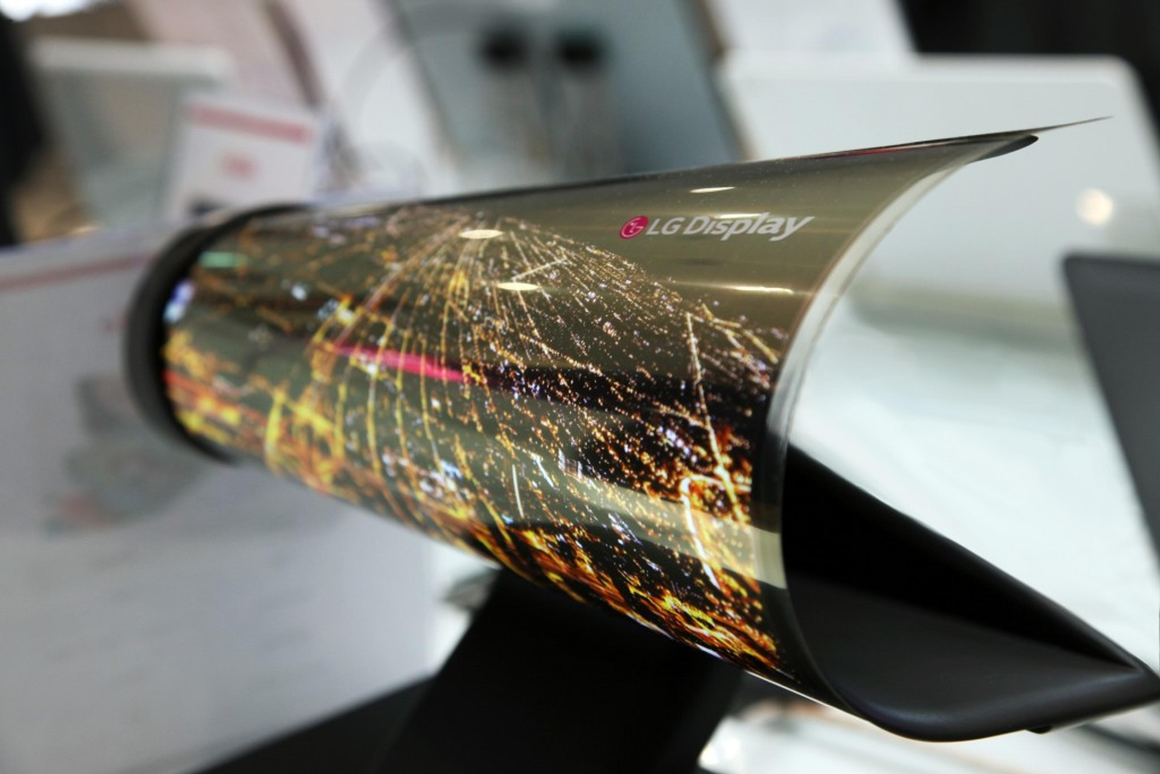 A curved LG Display screen showcasing a vibrant cityscape at night. The display is positioned on a stand, highlighting its unique design.