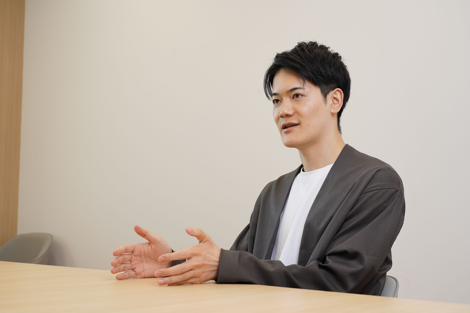 a man sitting at a table with his hands outstretched