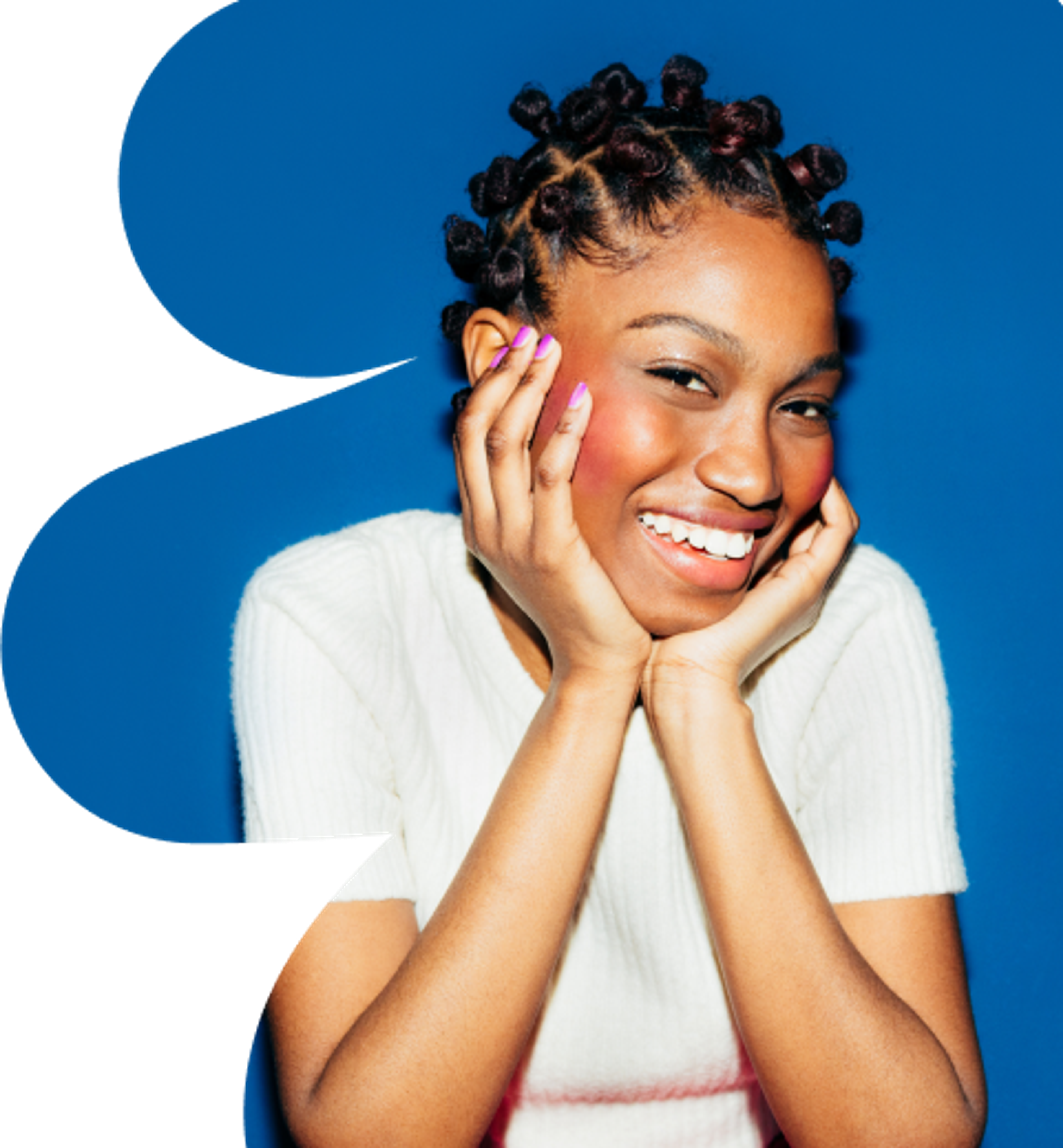 A smiling young woman with bantu knots poses with her hands on her cheeks against a bright blue background. She wears a white sweater and has a joyful expression.