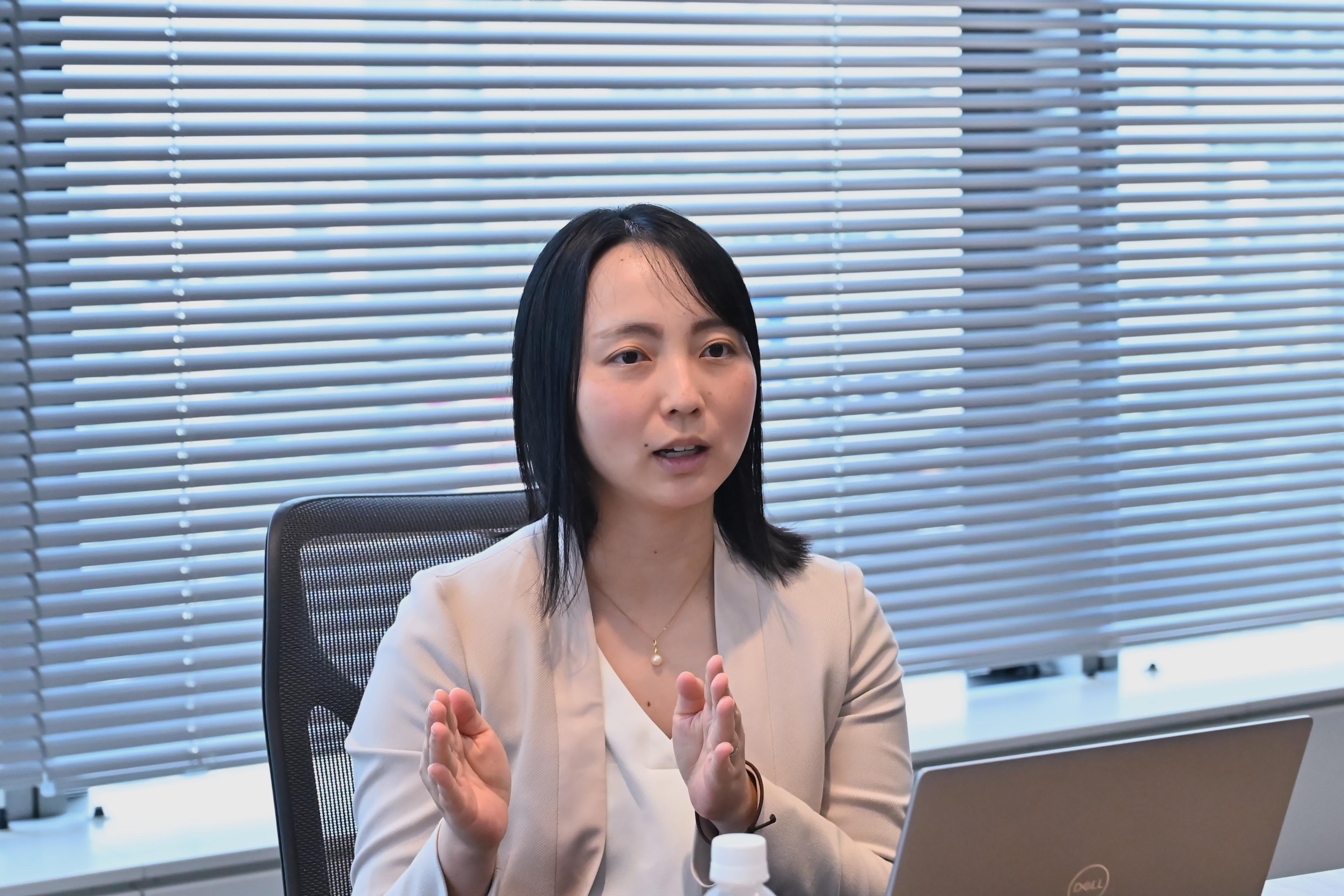 a woman is sitting in front of a laptop computer in an office .