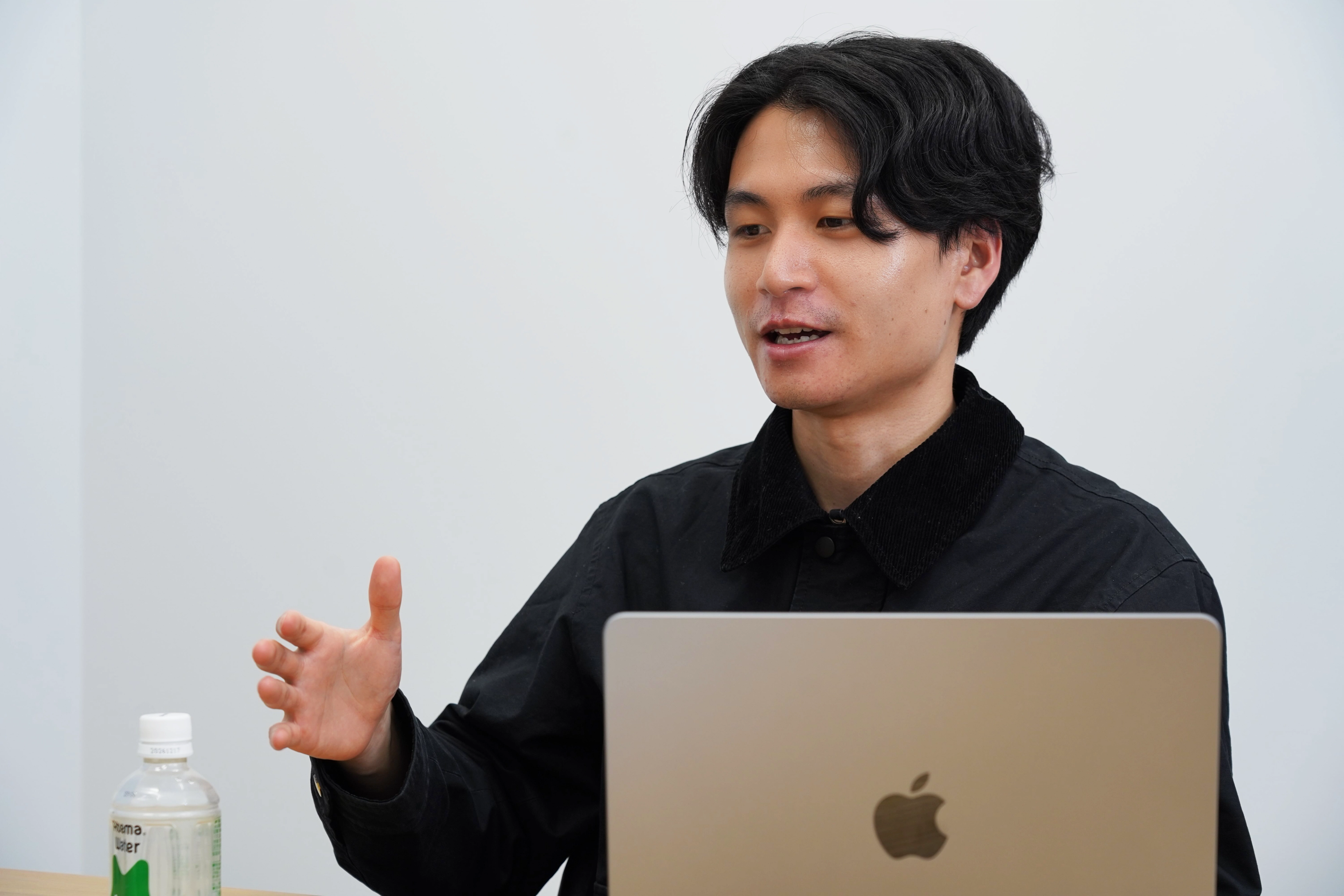 a man sitting in front of an apple laptop