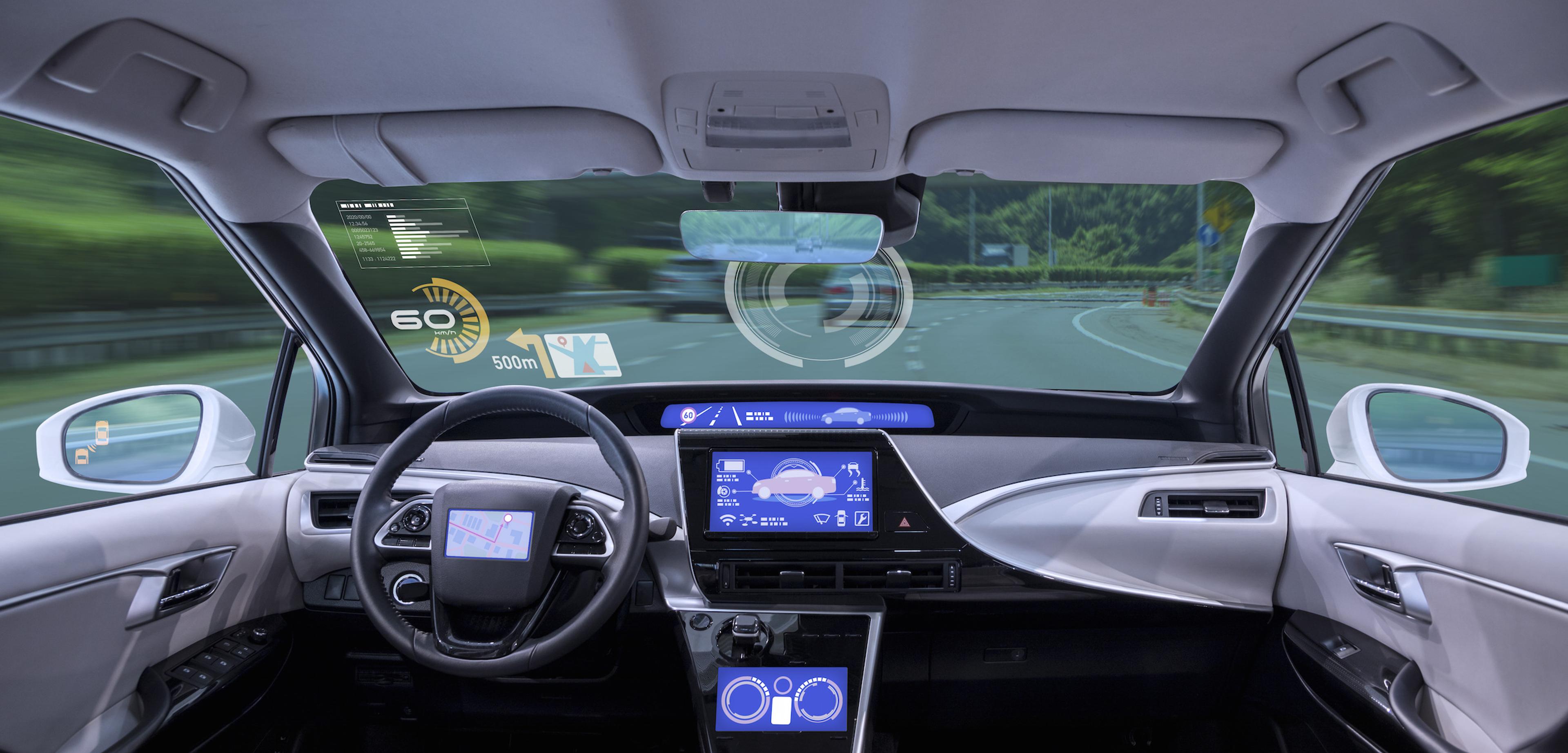 Interior view of a modern car with a digital dashboard displaying speed and navigation information, while driving on a curved road.
