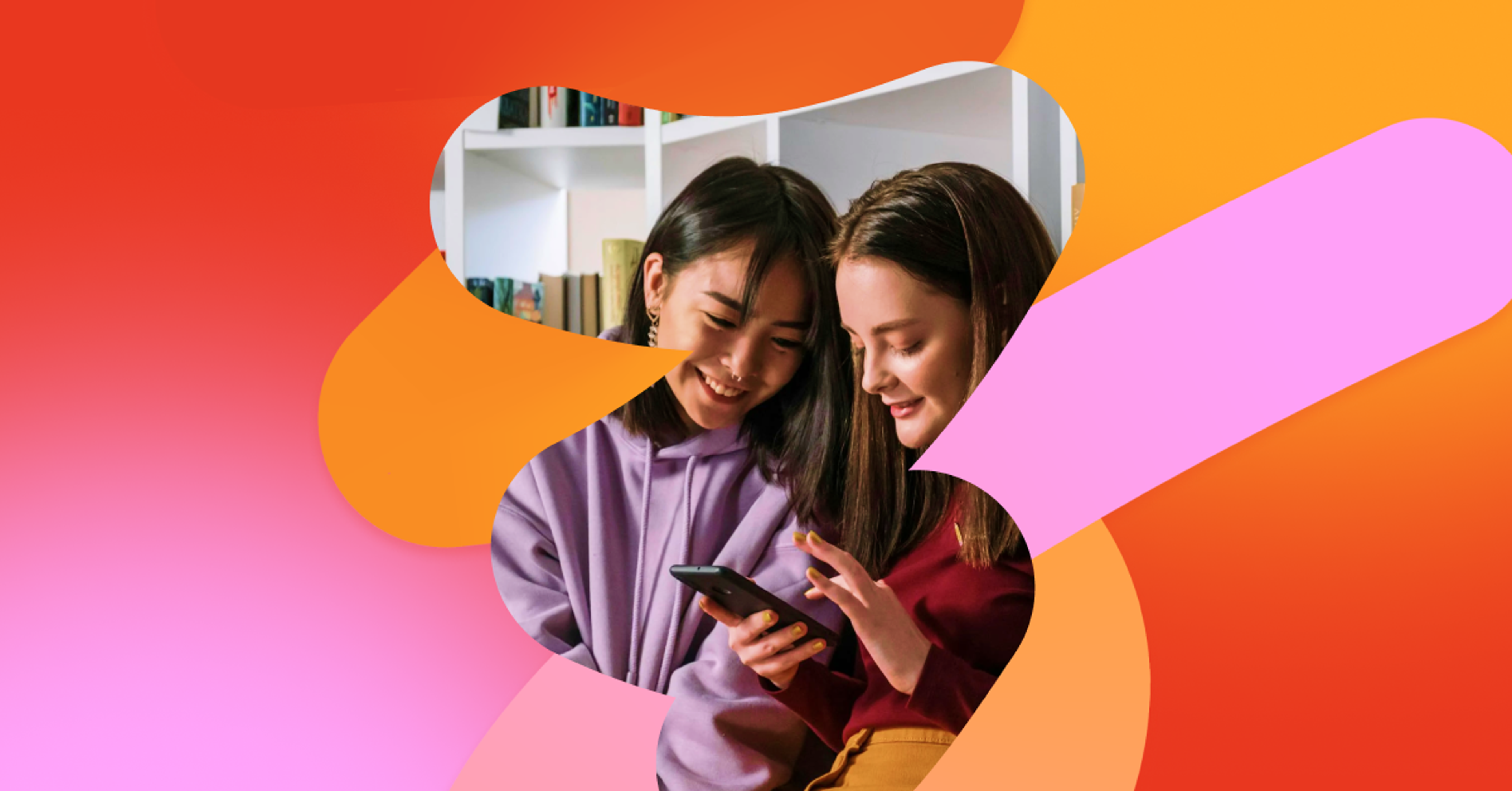 two girls are looking at a cell phone together