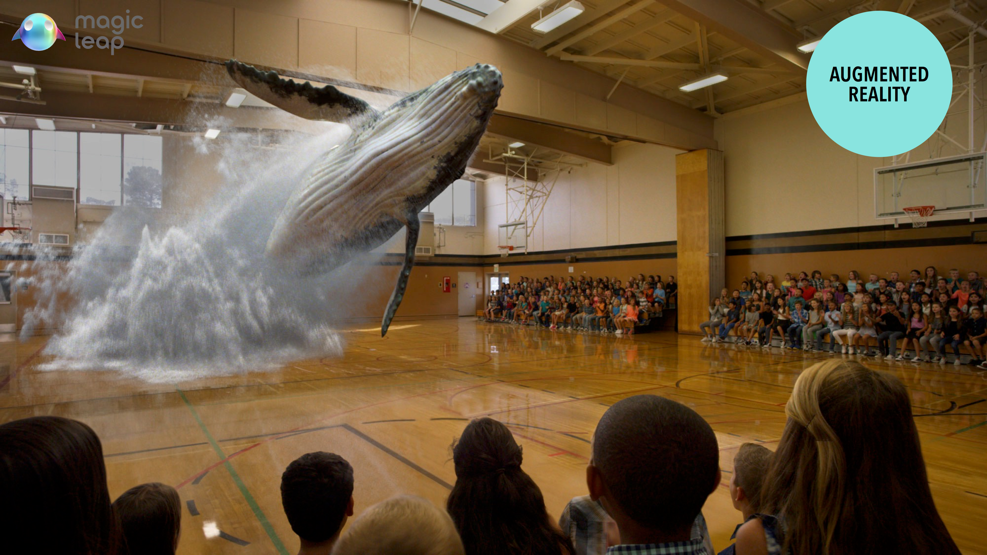 A large humpback whale appears to leap out of the gymnasium, surrounded by an audience watching in awe. The scene showcases augmented reality technology.
