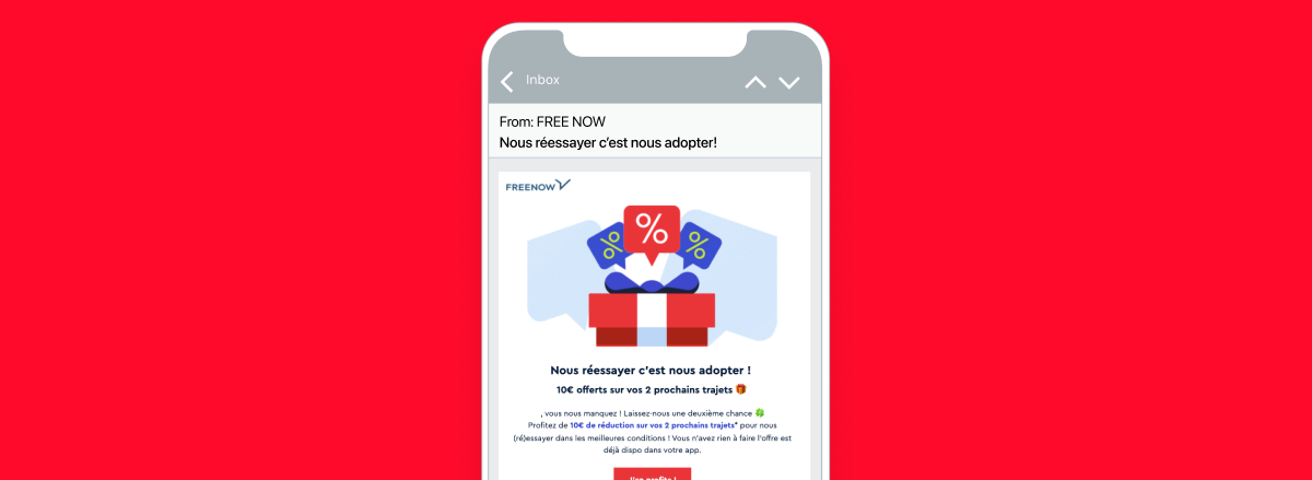 Un smartphone affichant un e-mail promotionnel de FREE NOW avec une offre de réduction sur des produits. L'arrière-plan est rouge.
