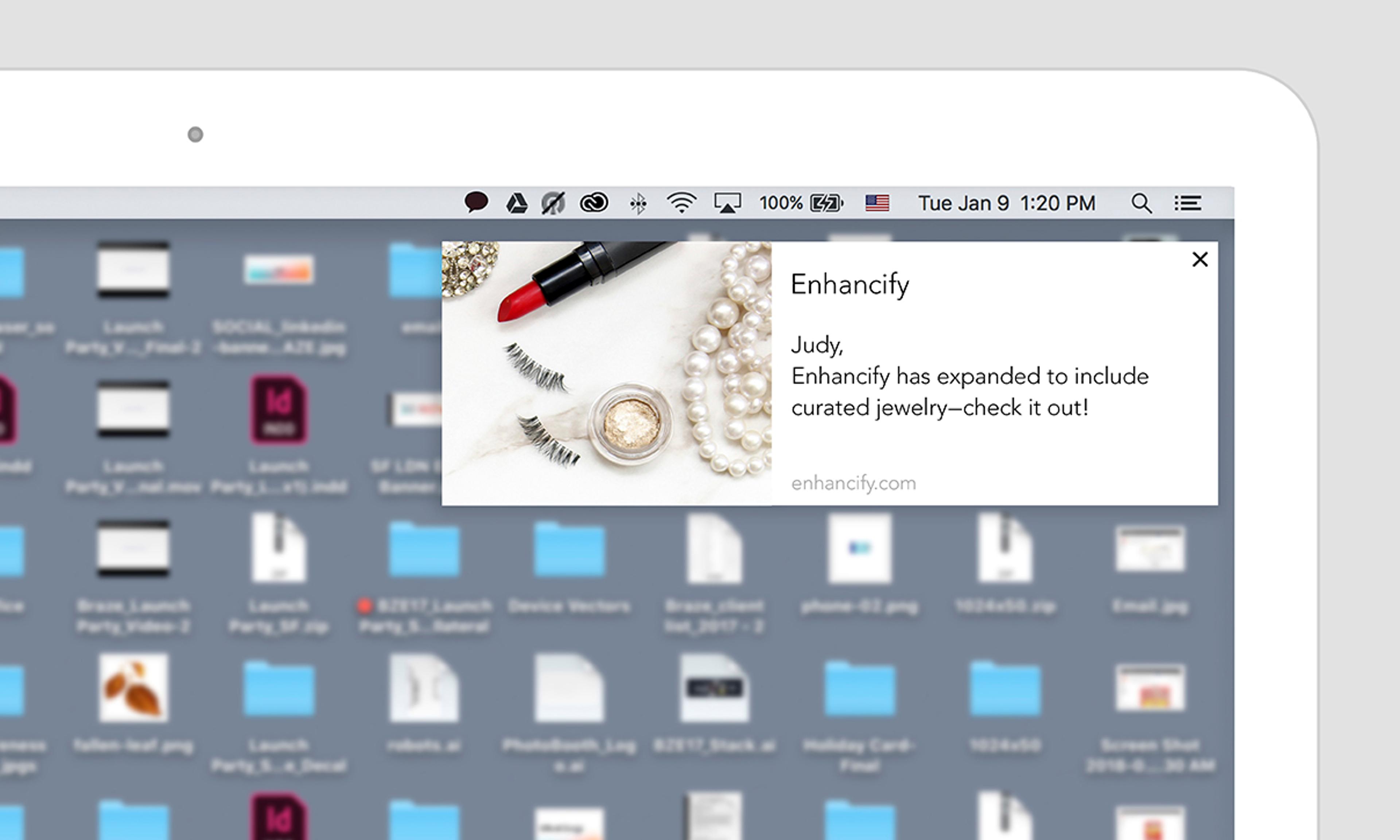 A pop-up notification on a laptop screen announces that Enhancify has expanded to include curated jewelry. The notification features images of jewelry items, including pearls and a lipstick.