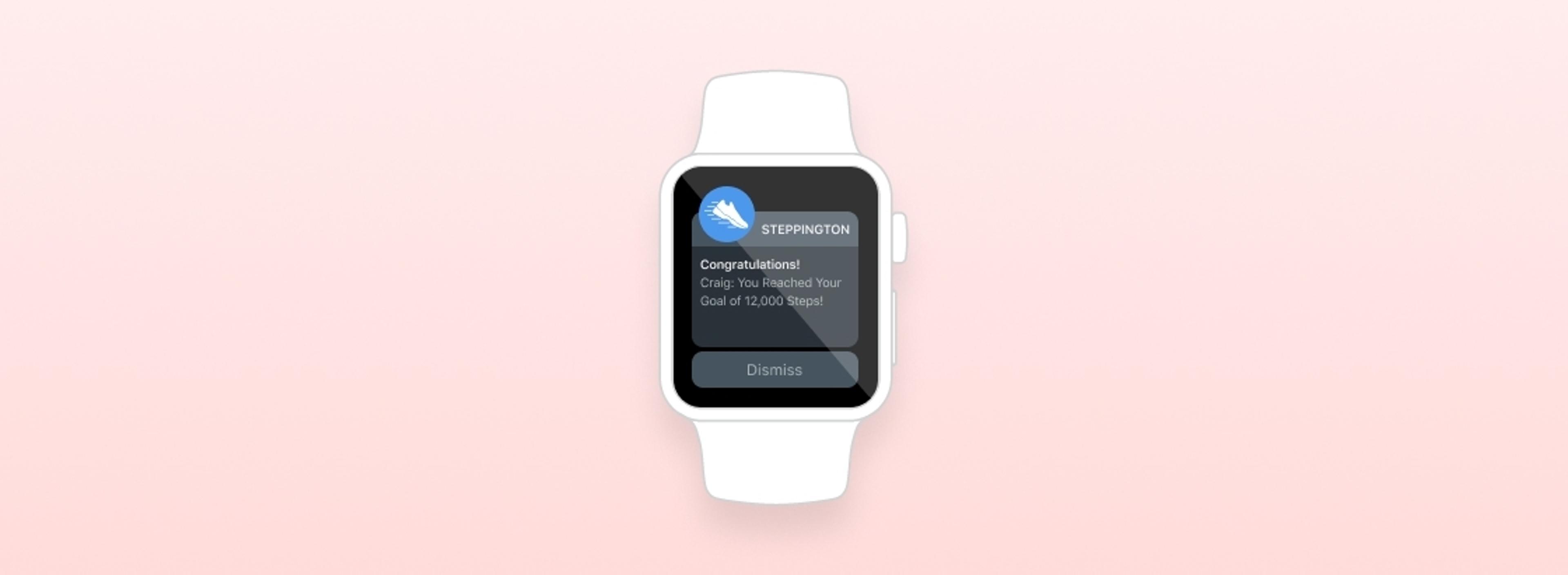 A smartwatch displaying a notification that congratulates the user for reaching a goal of 10,000 steps. The background is a soft pink color.