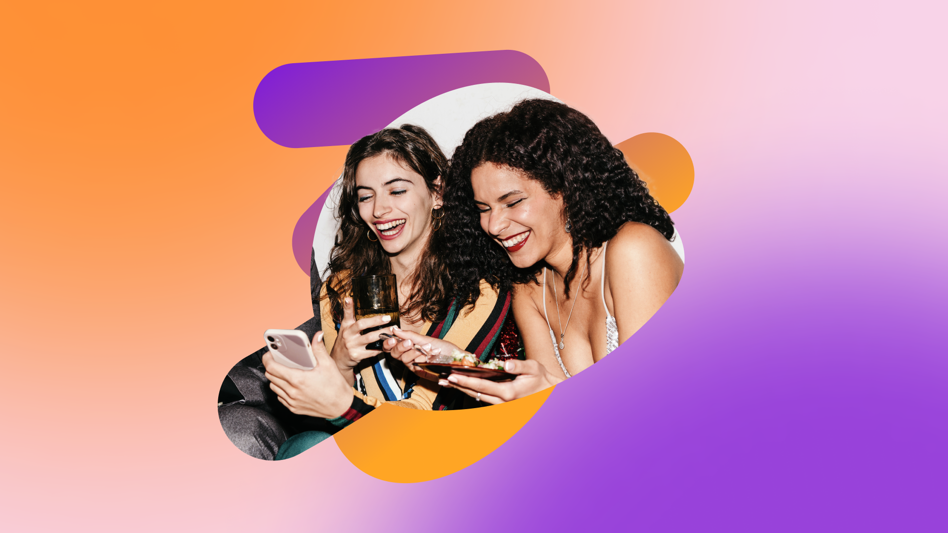 two women are laughing while looking at their phones