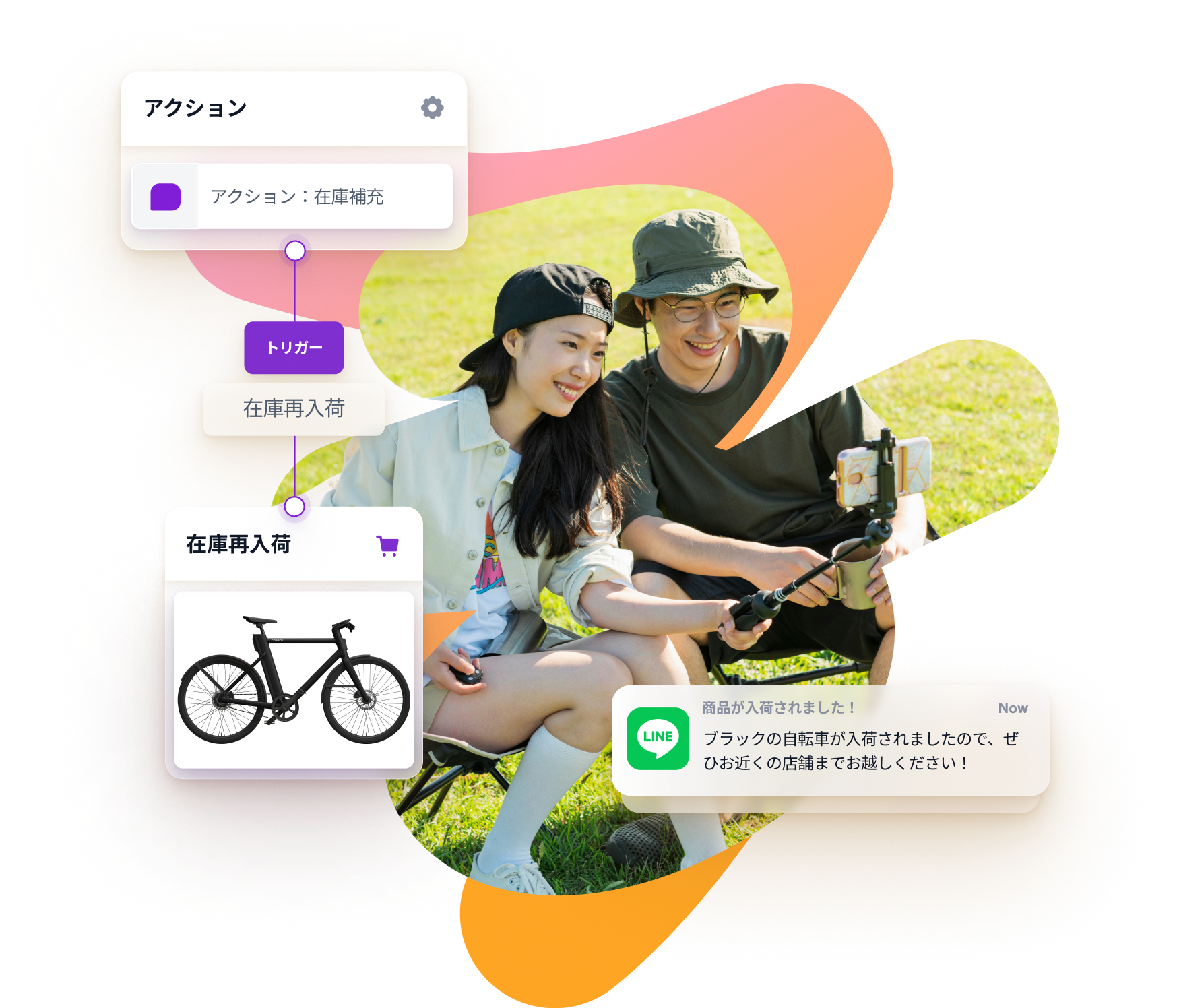 a man and a woman are sitting in the grass with a bicycle in the background