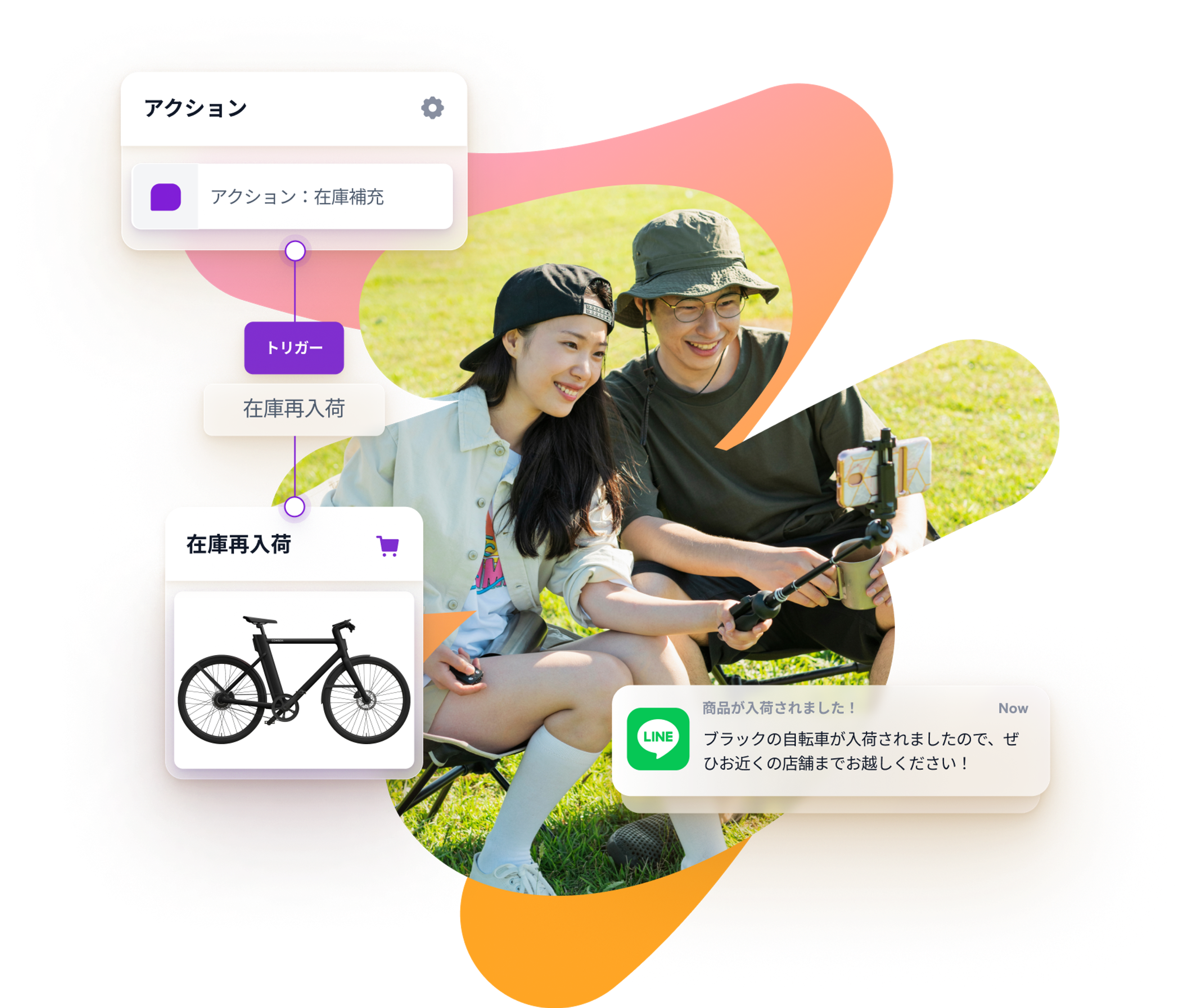 a man and a woman are sitting in the grass with a bicycle in the background