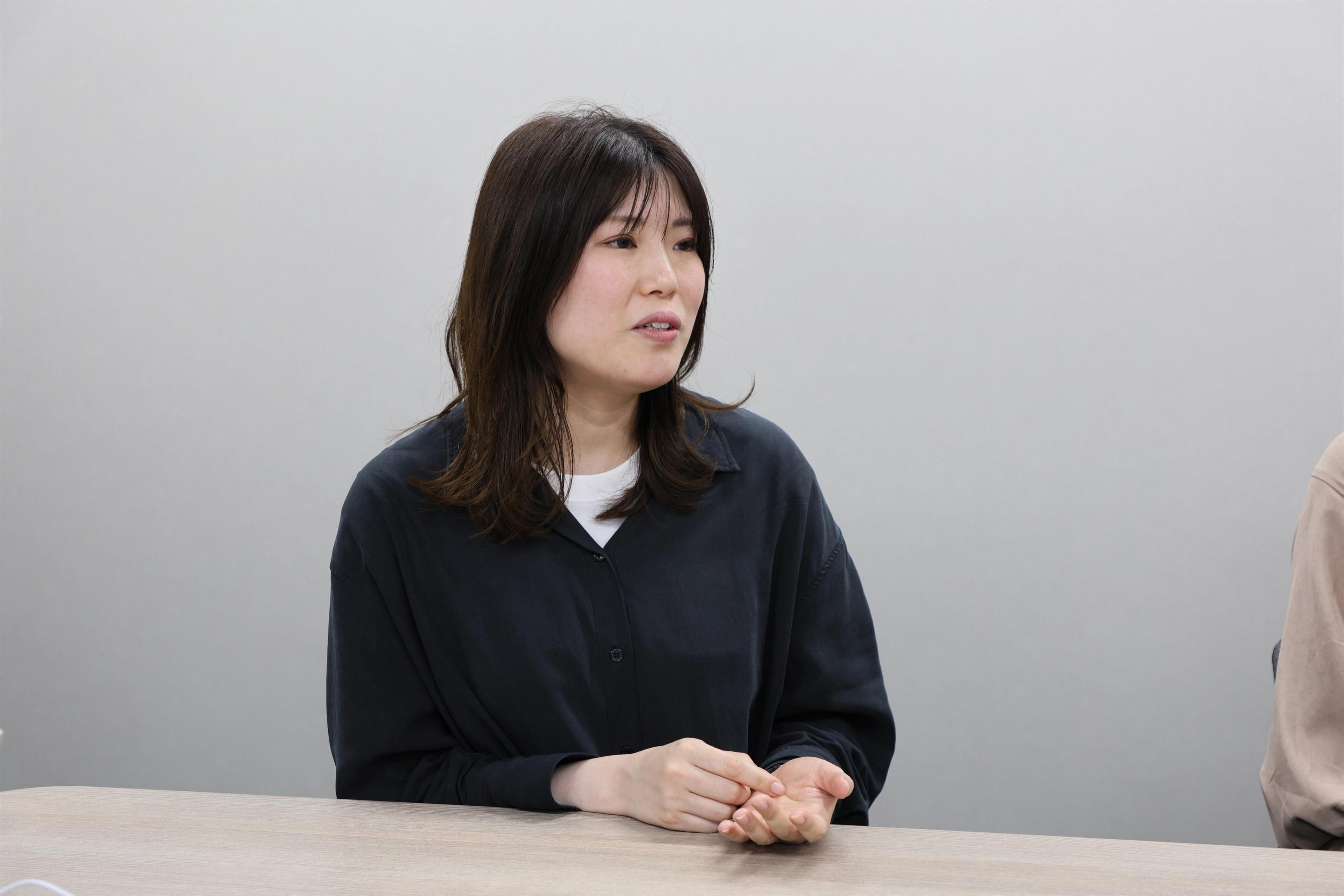 OMO本部マーケティング部 畑中 まみな氏
がインタビューを受けている様子。黒色のシャツをきていて笑顔で話をしている