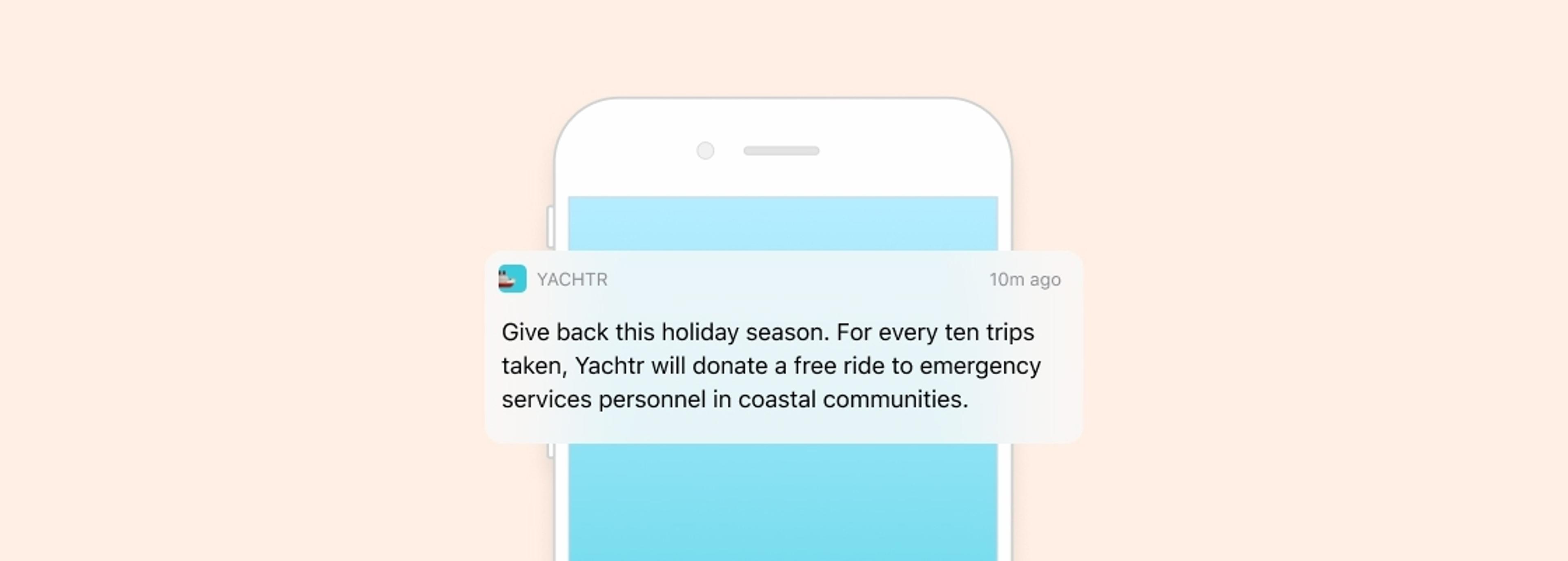 A smartphone notification from Yachtr announces a holiday season initiative to donate free rides to emergency services personnel for every ten trips taken. The background is a soft pastel color.
