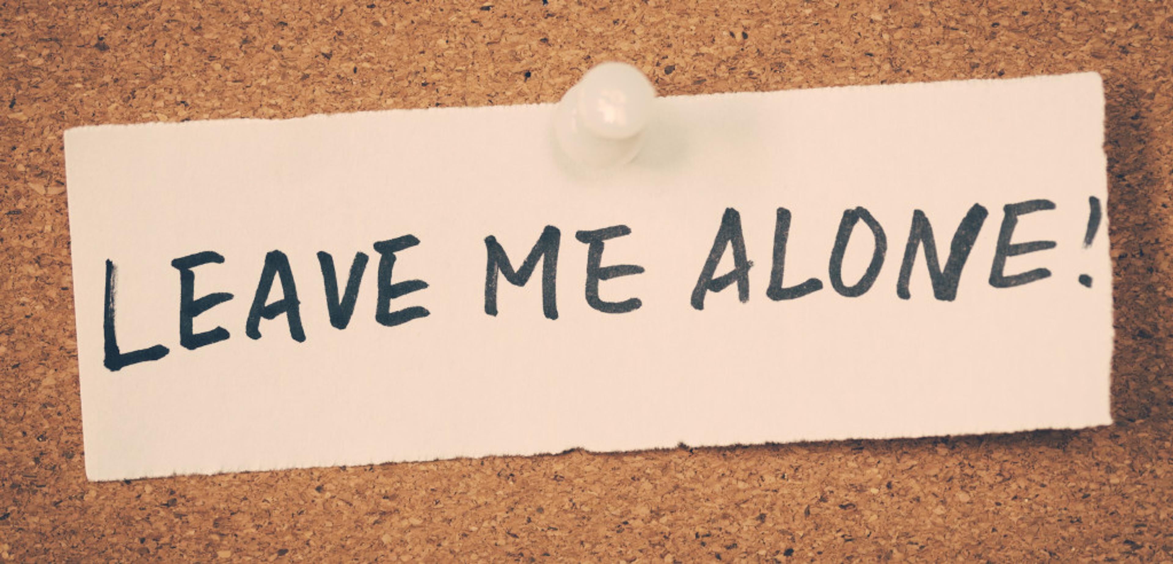 A note pinned to a corkboard that reads "LEAVE ME ALONE!" in bold letters.