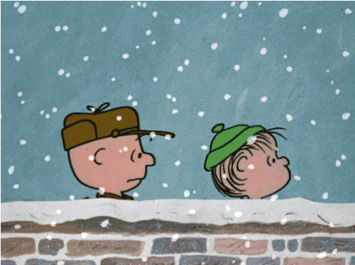 Two cartoon characters, one wearing a brown cap and the other in a green hat, are looking up at falling snowflakes against a blue background.
