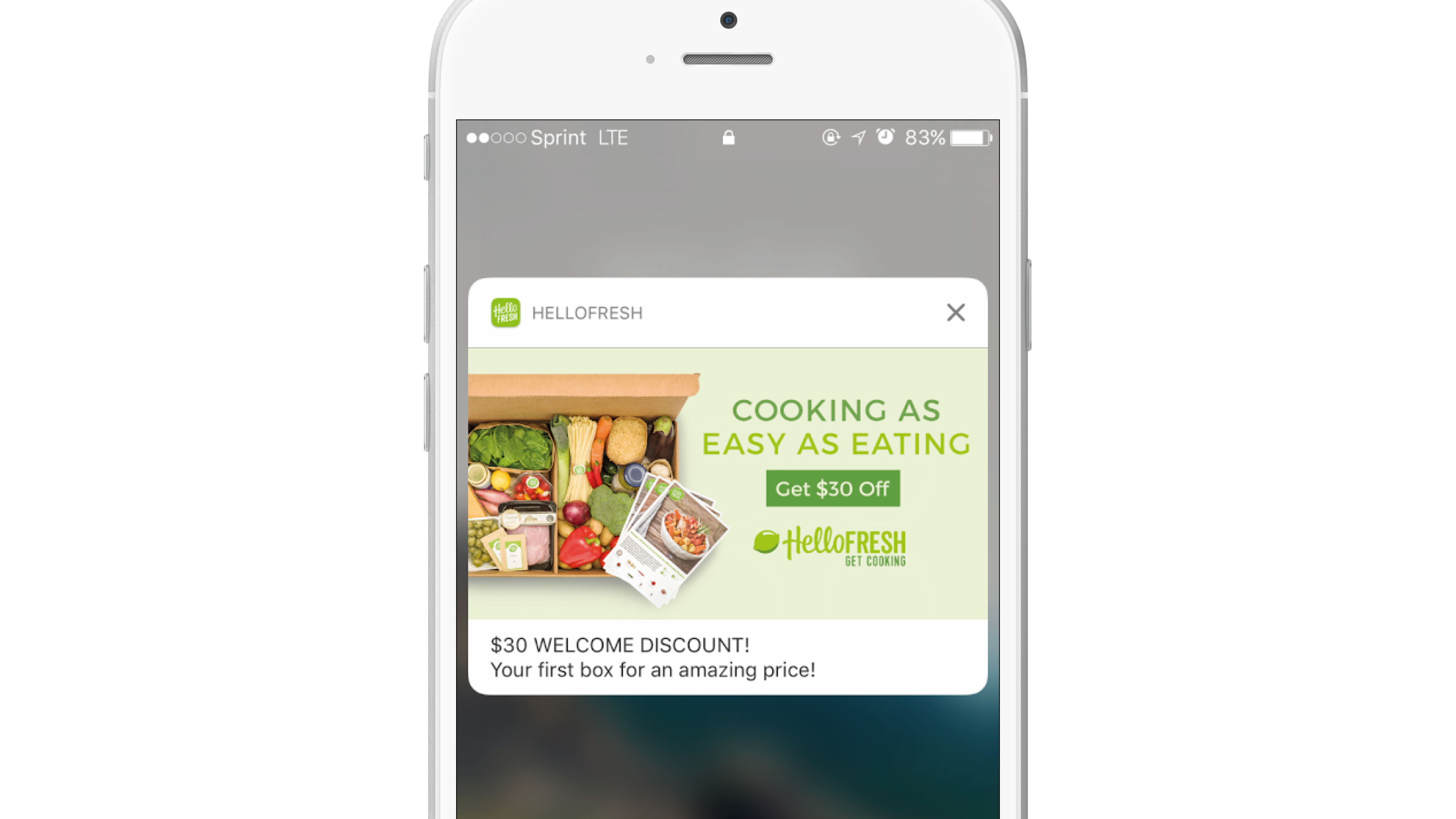 A smartphone screen displaying a HelloFresh advertisement offering a $30 discount on the first box of meal kits. The background features fresh ingredients and a meal kit box.