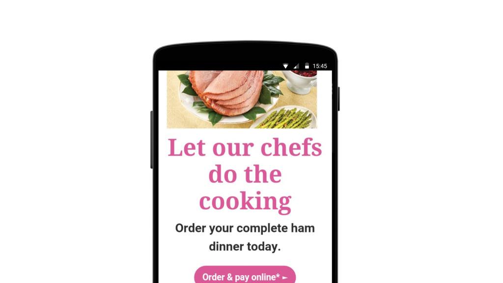 A smartphone screen displaying an advertisement for ordering a complete ham dinner, featuring sliced ham and a call to action to order online.