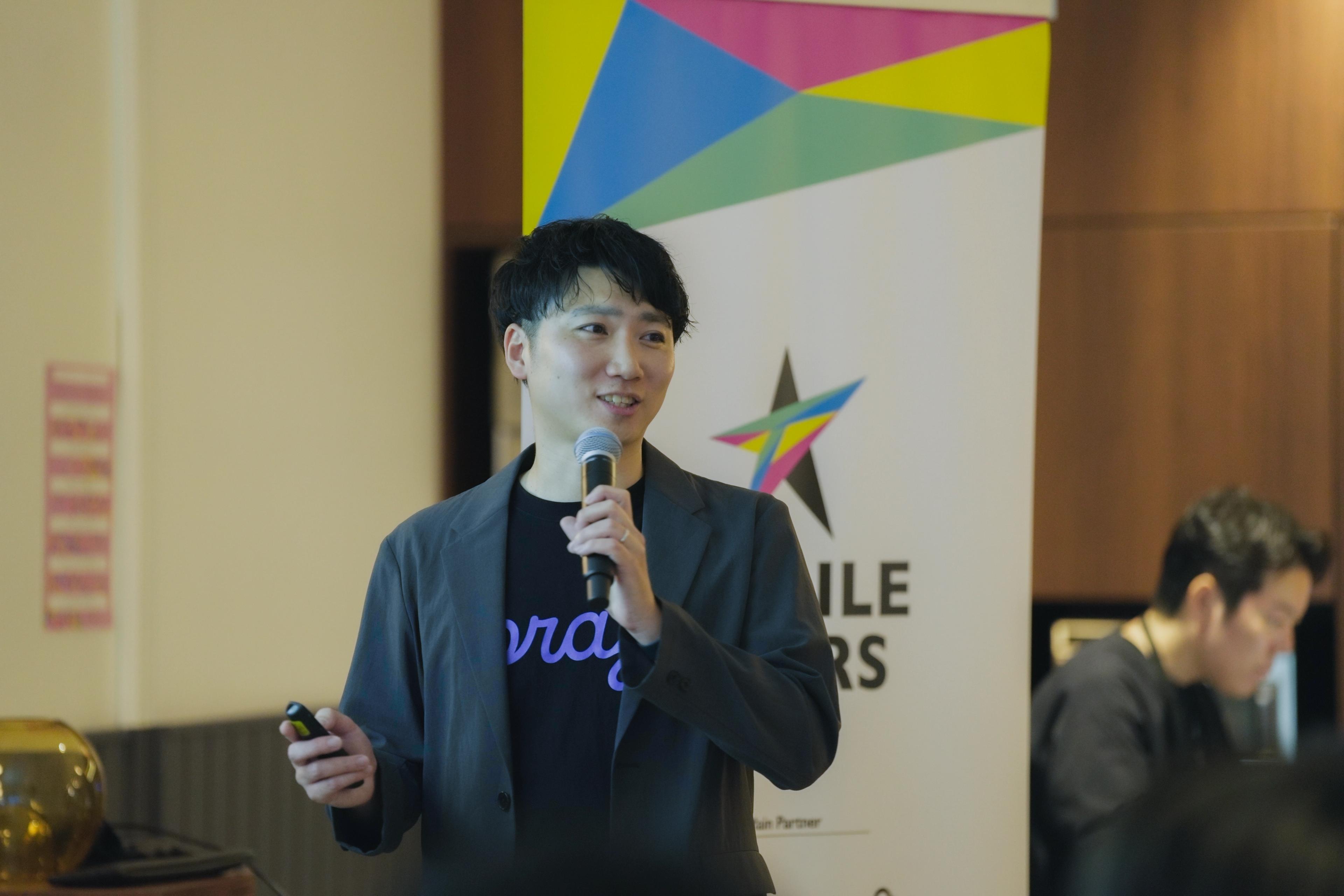a man is standing in front of a microphone giving a presentation .
