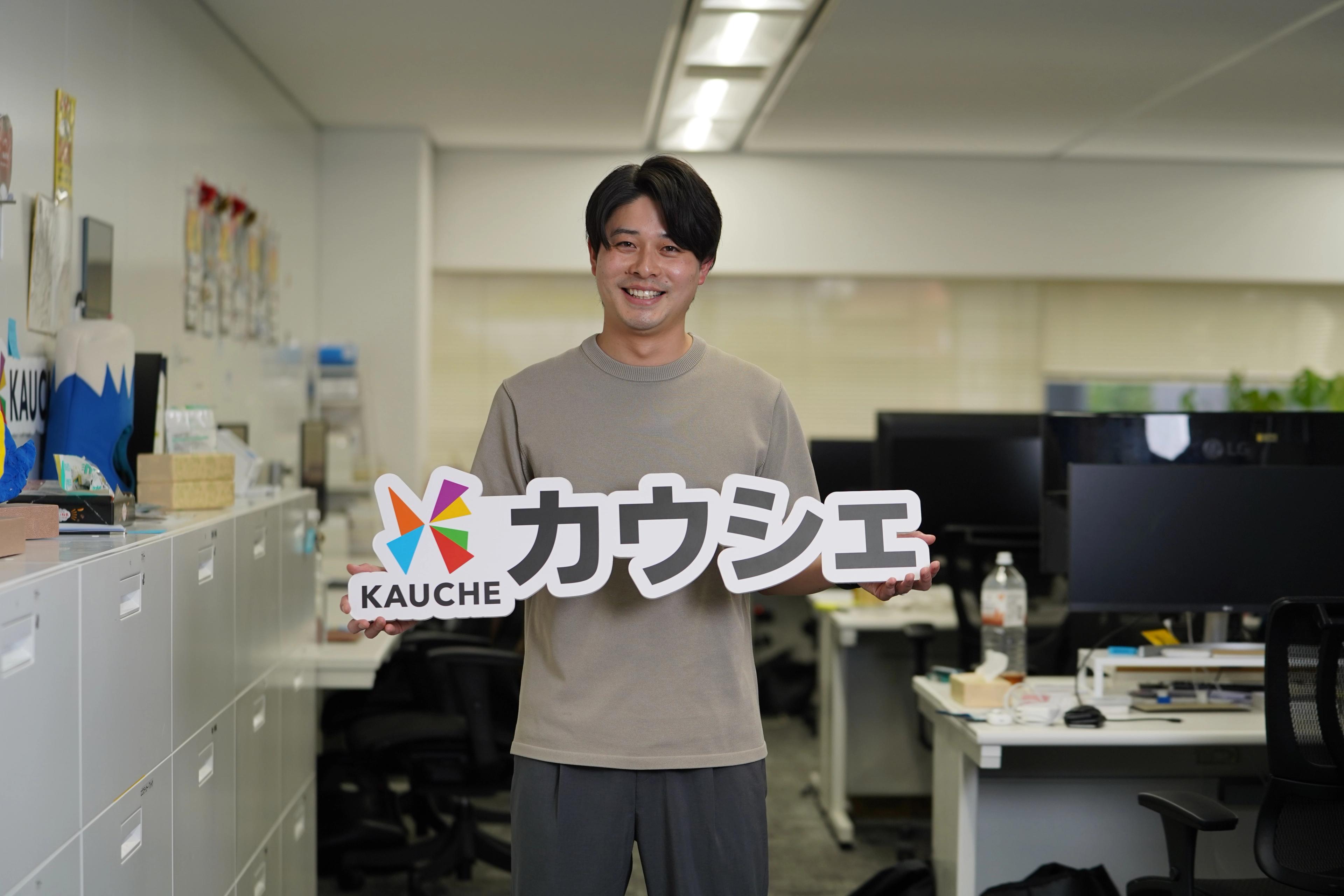 カウシェ執行役員CMOの前本航太さんがカウシェのロゴをもっている
