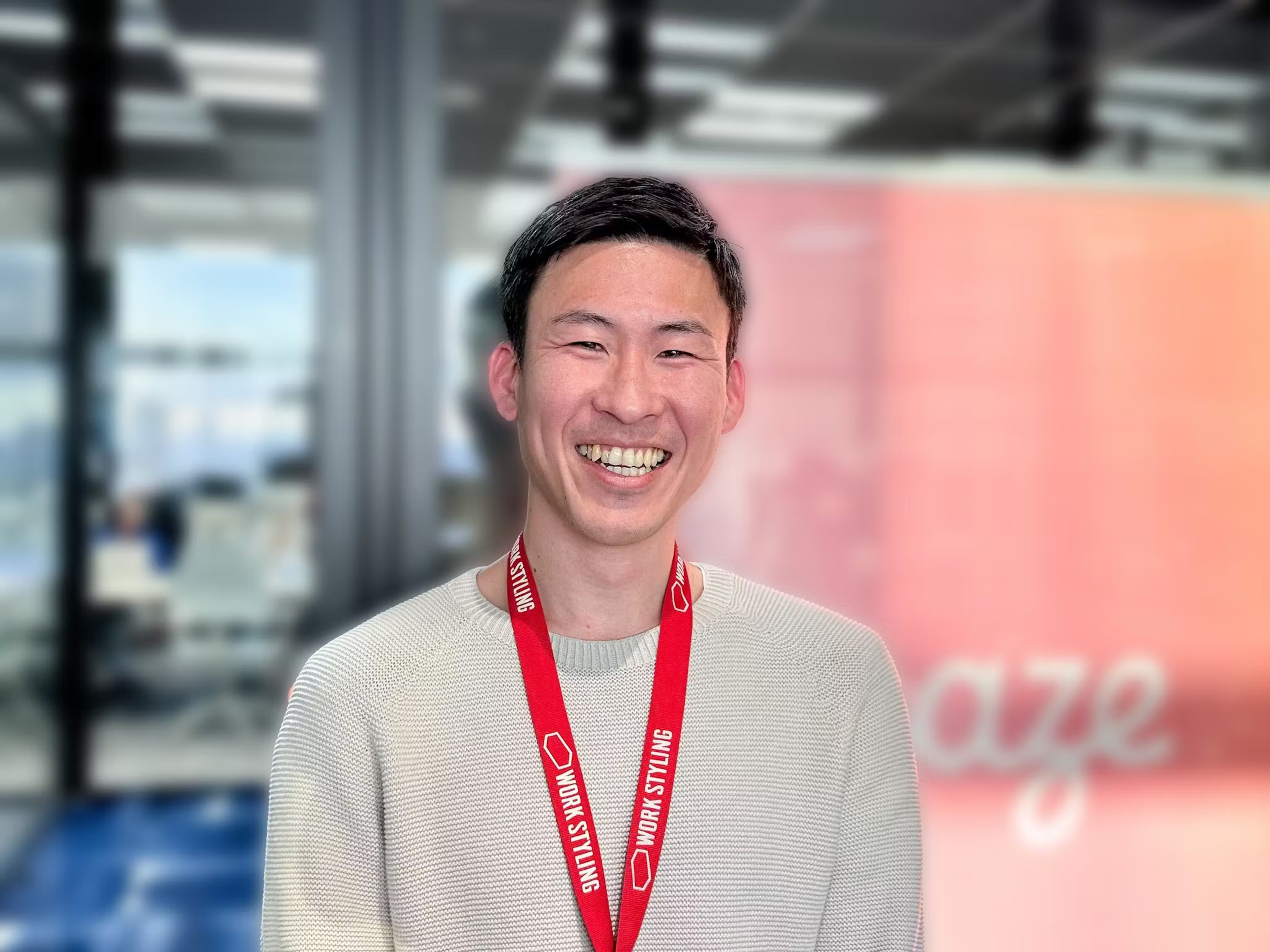 a man wearing a work styling lanyard smiles for the camera