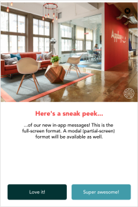 A modern office space featuring a cozy seating area with chairs and a coffee table. A red wall displays the word "Appy" and there are people working in the background.