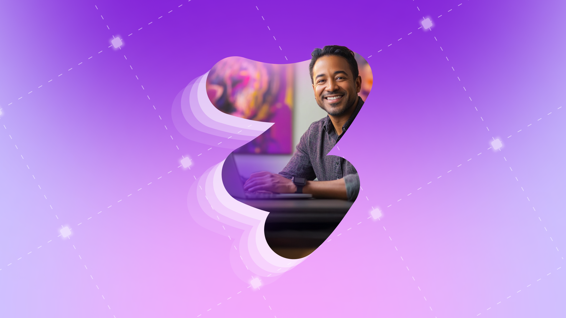 a man is smiling while using a laptop on a purple background