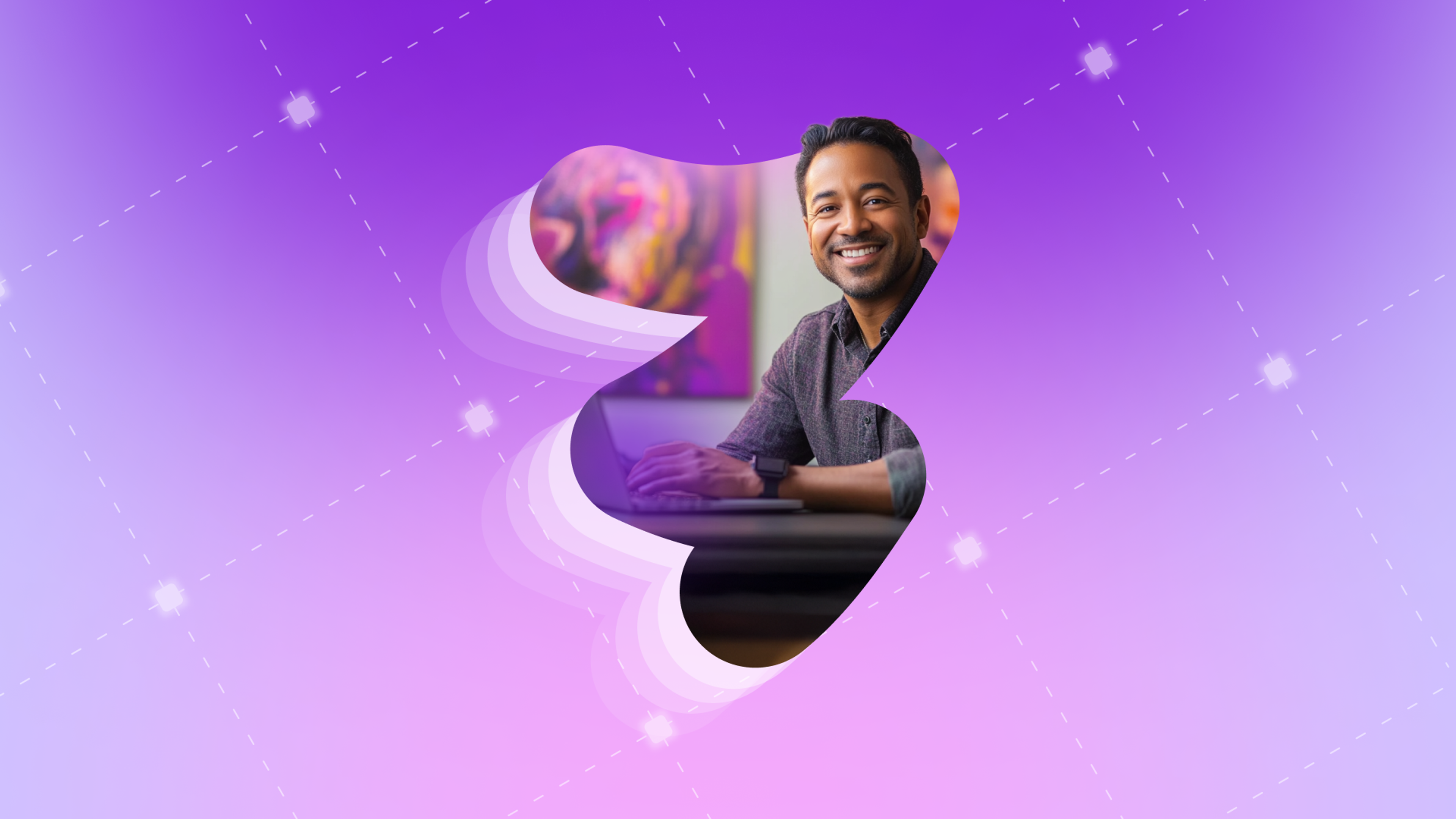a man is smiling while using a laptop on a purple background