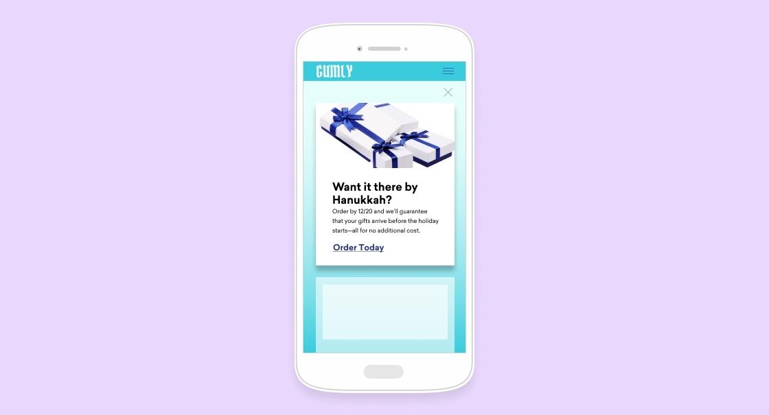 A mobile phone screen displaying a holiday gift advertisement with a prompt to order by Hanukkah. The background is a light purple color.