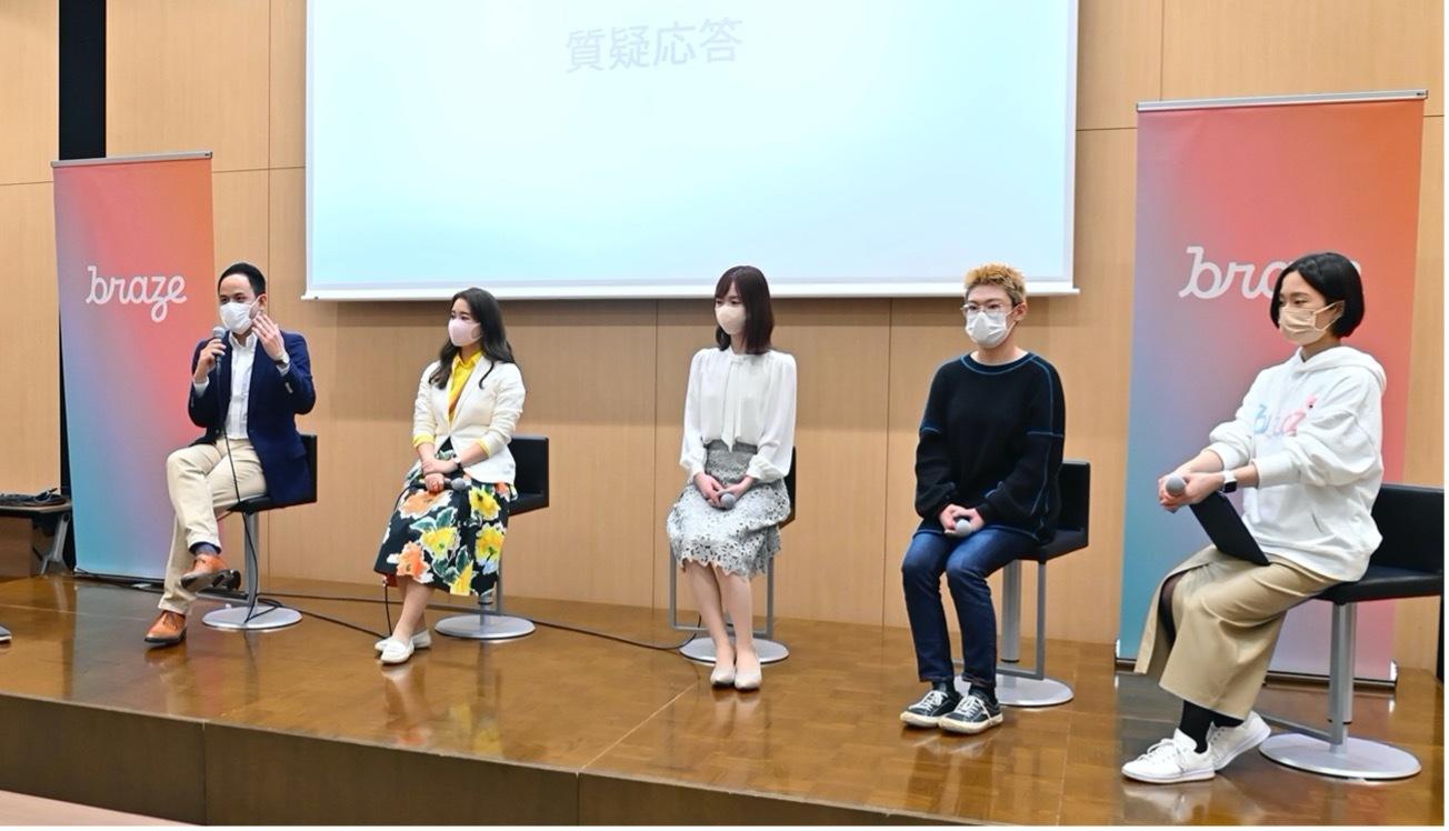 パネルディスカッションの様子。5人の参加者がマスクを着用し、質問に答えています。