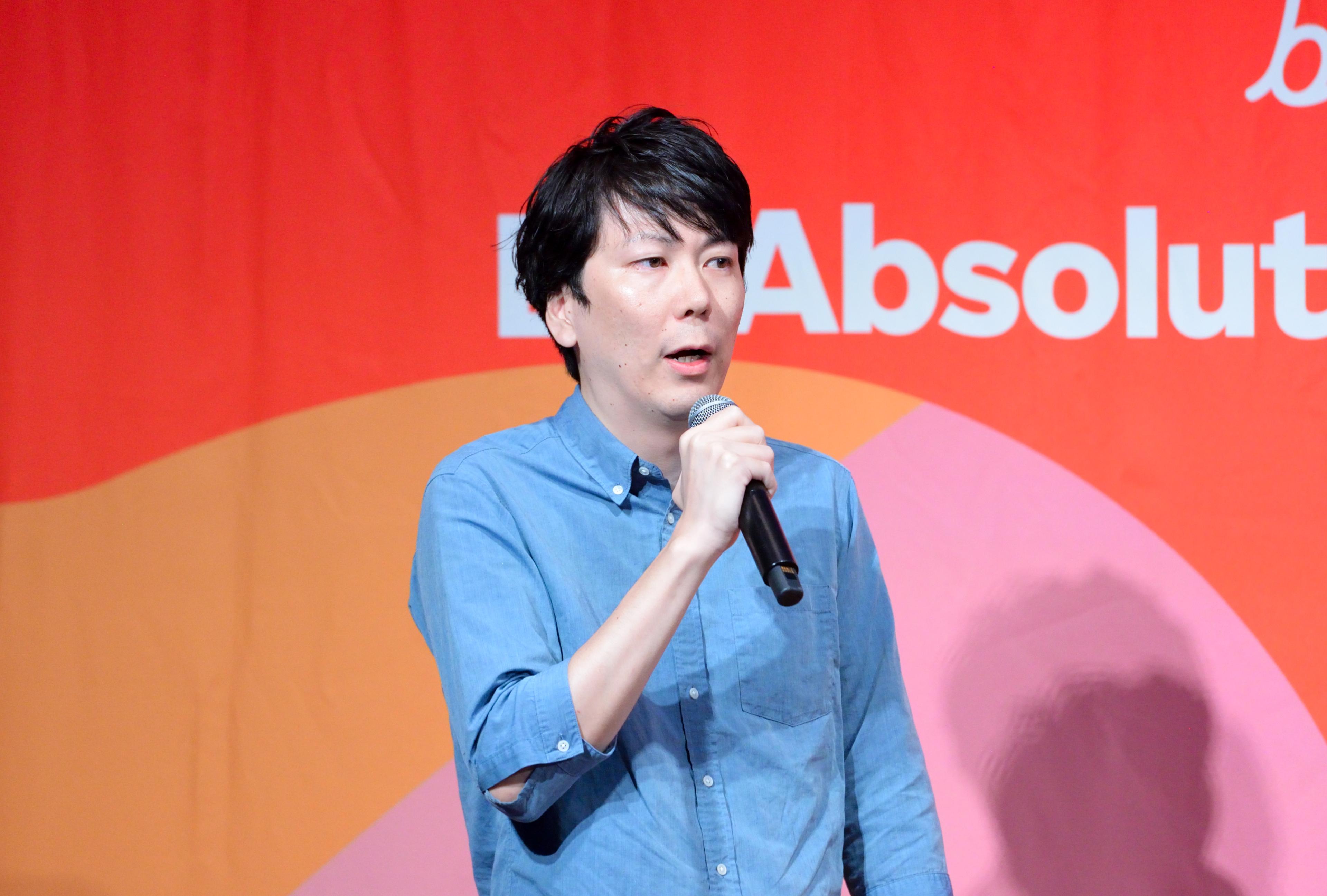 a man is holding a microphone in front of a red background .