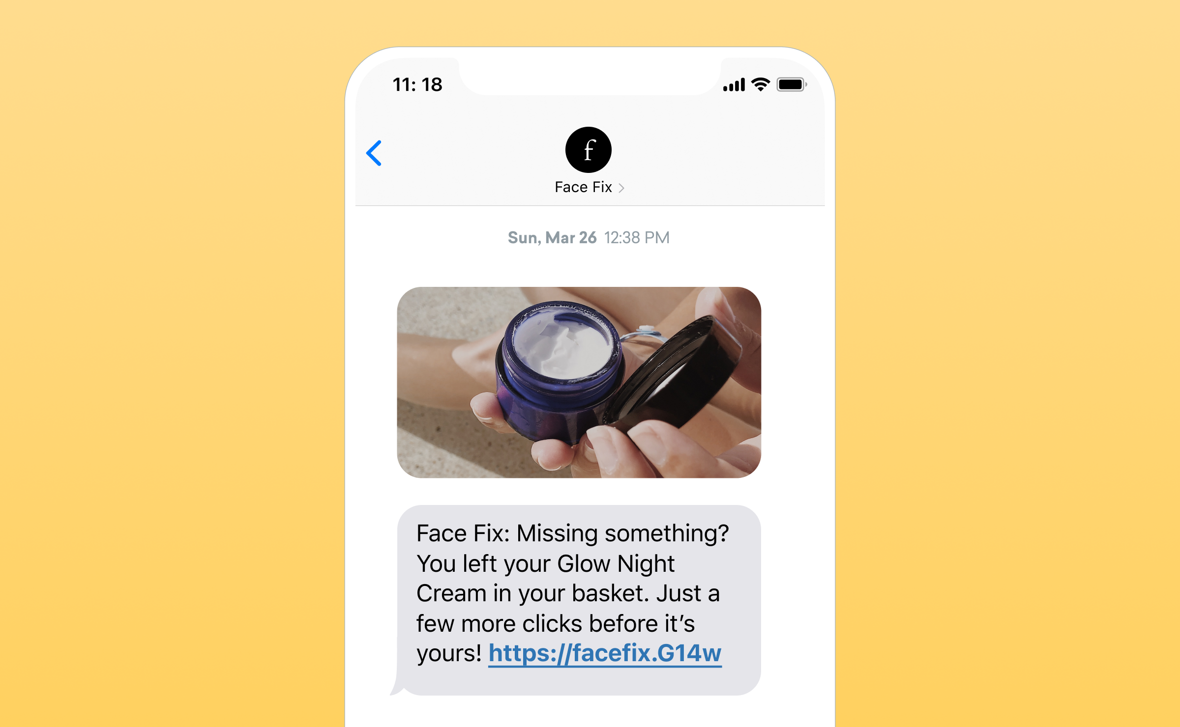 A smartphone screen displaying a text message reminder about a Glow Night Cream left in a shopping basket, along with a photo of the cream in a blue jar.