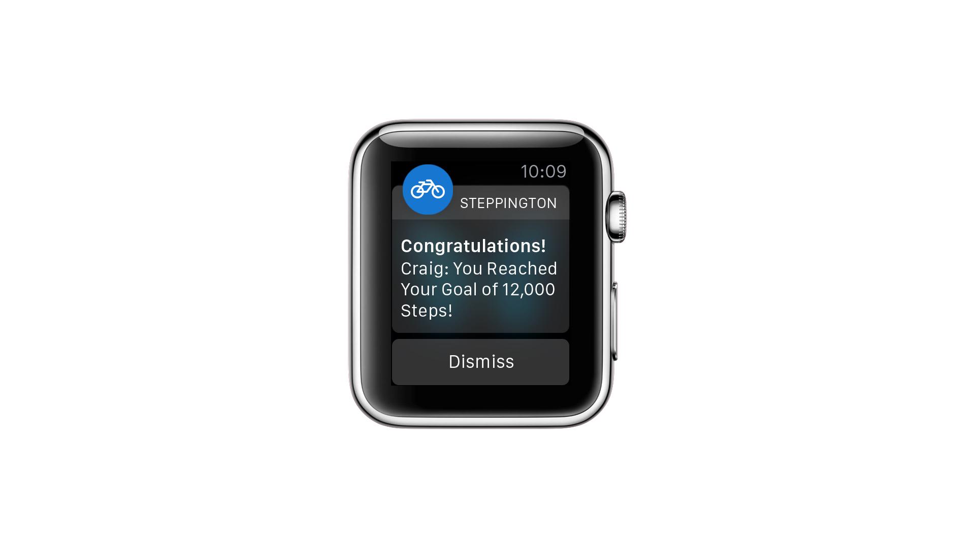 A smartwatch displays a notification congratulating the user, Craig, for reaching a goal of 12,000 steps. The screen shows options to dismiss the notification.