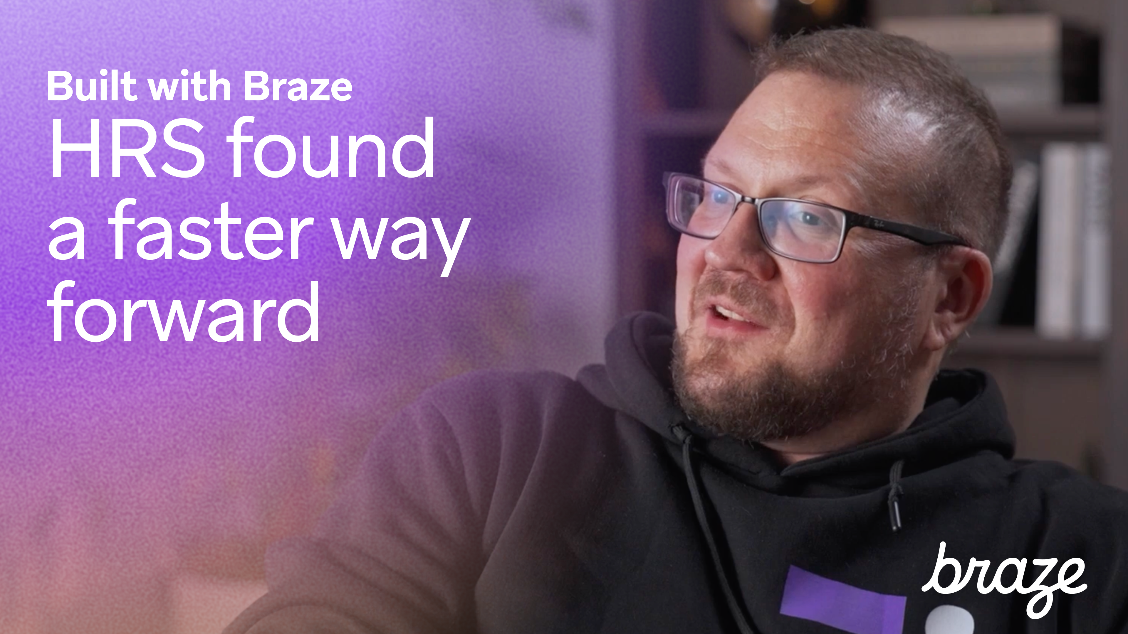 Smiling man sits in an office setting beside text that reads, “Built with Braze – HRS found a faster way forward” with the Braze logo in the corner.
