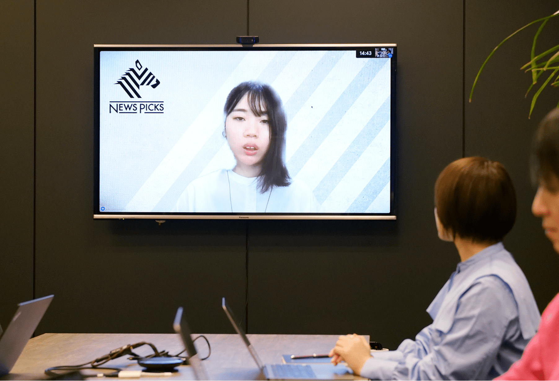 画面に映る女性が話している様子。左側には会議に参加している人々が見える。