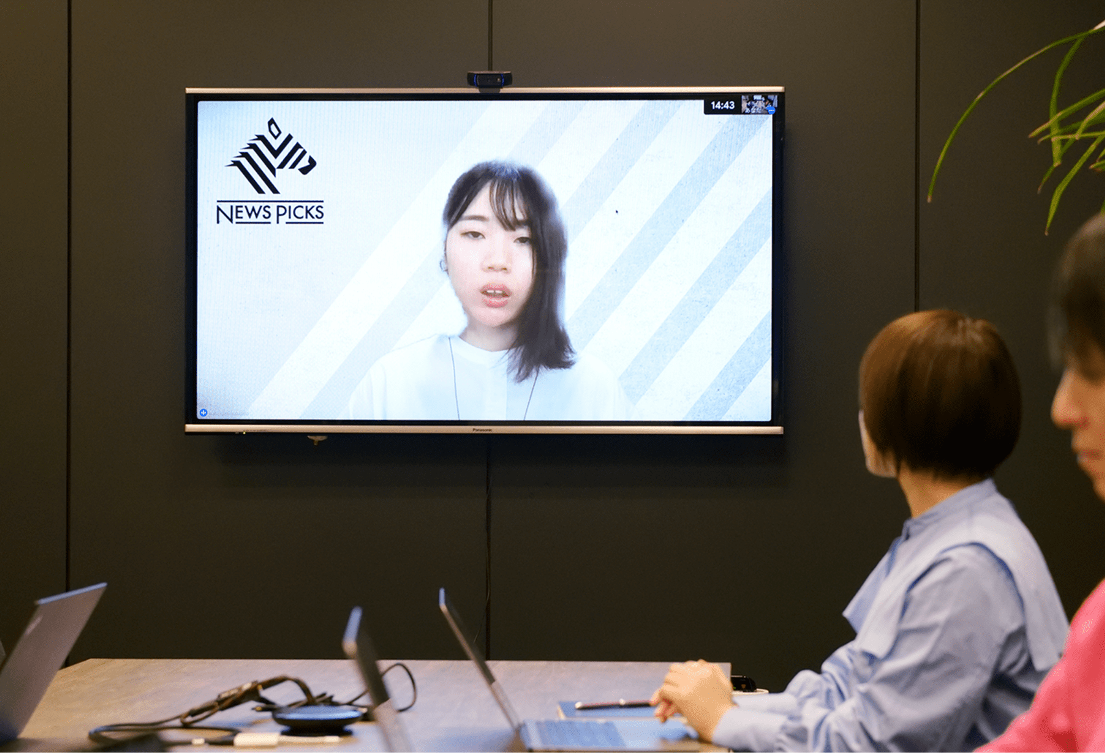 画面に映る女性が話している様子。左側には会議に参加している人々が見える。