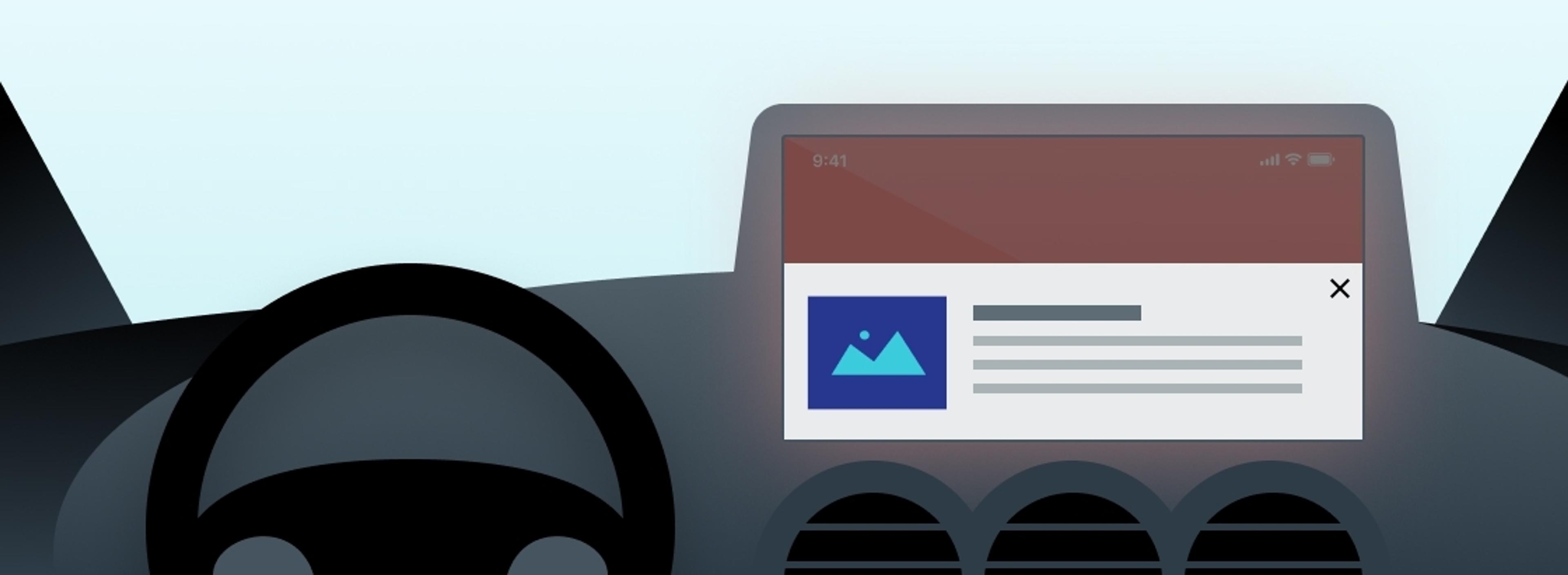 A digital dashboard display inside a car shows a notification with an image icon and text. The steering wheel is visible in the foreground.