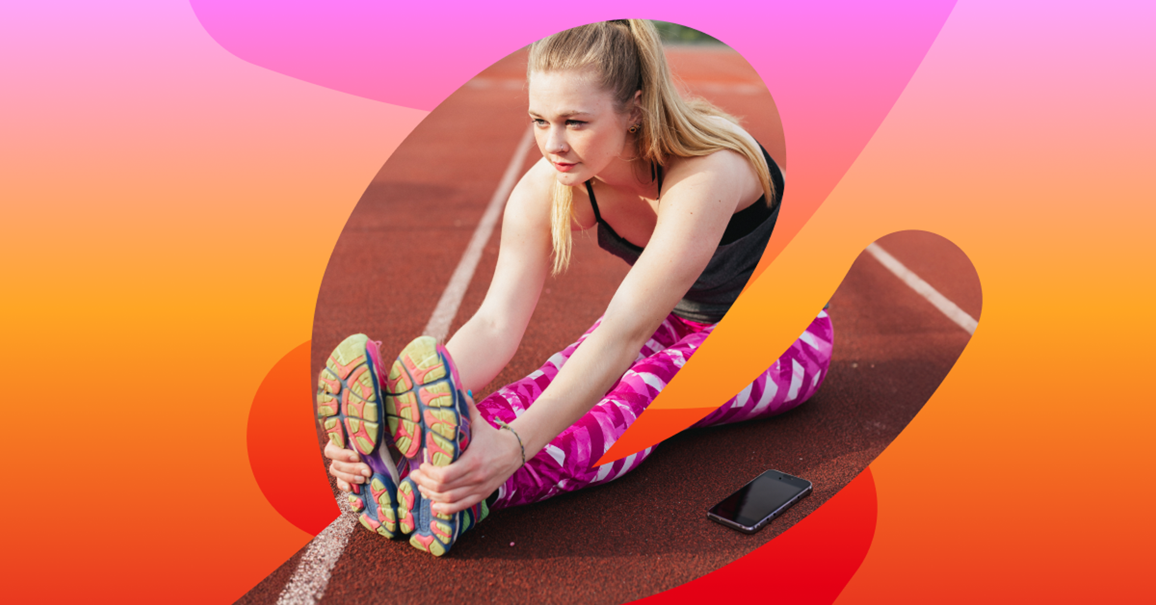a woman sits on a track stretching her legs 
