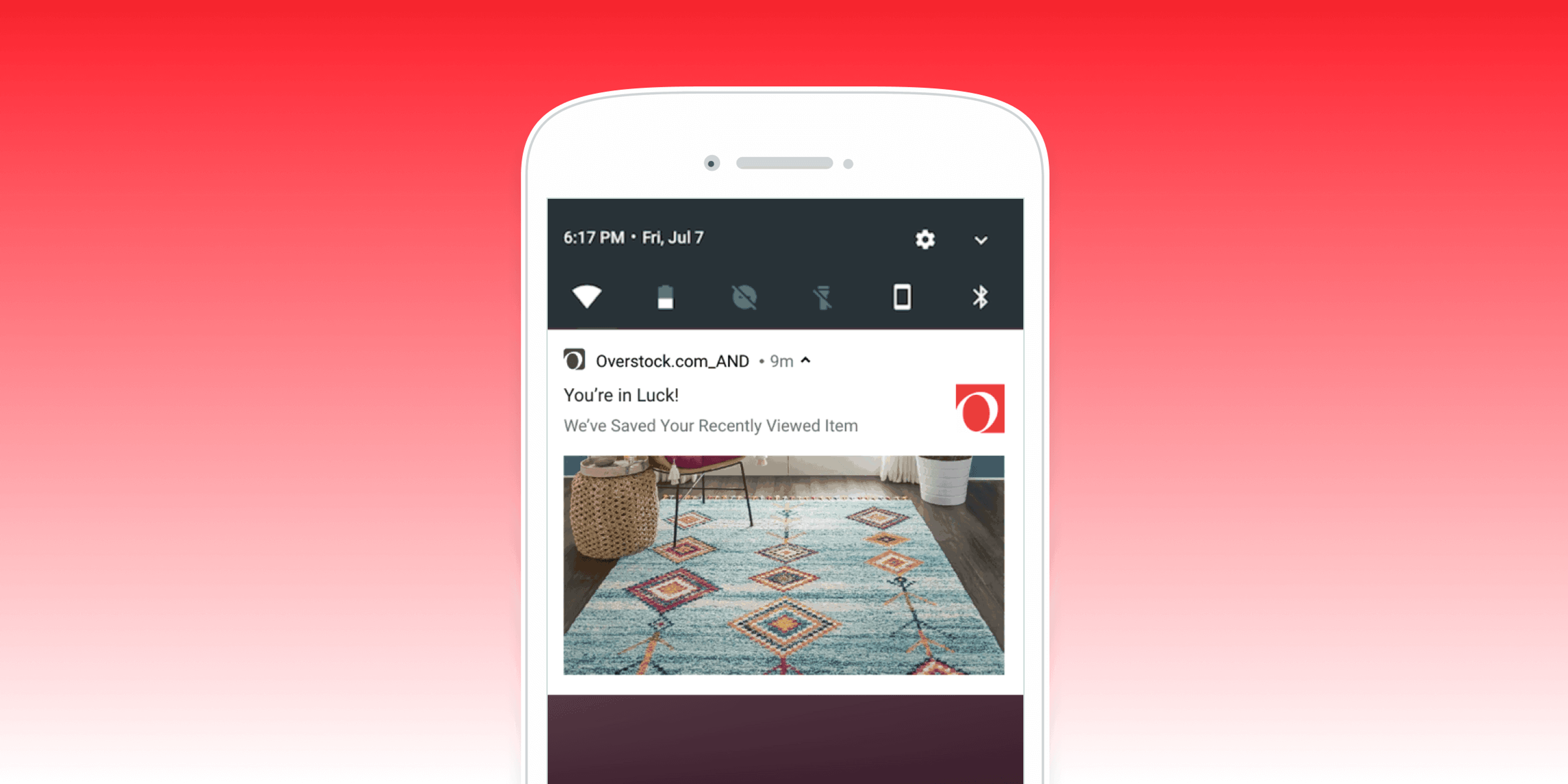 A smartphone screen displaying a notification from Overstock.com about a recently viewed item, featuring a colorful area rug. The background is a gradient from red to pink.