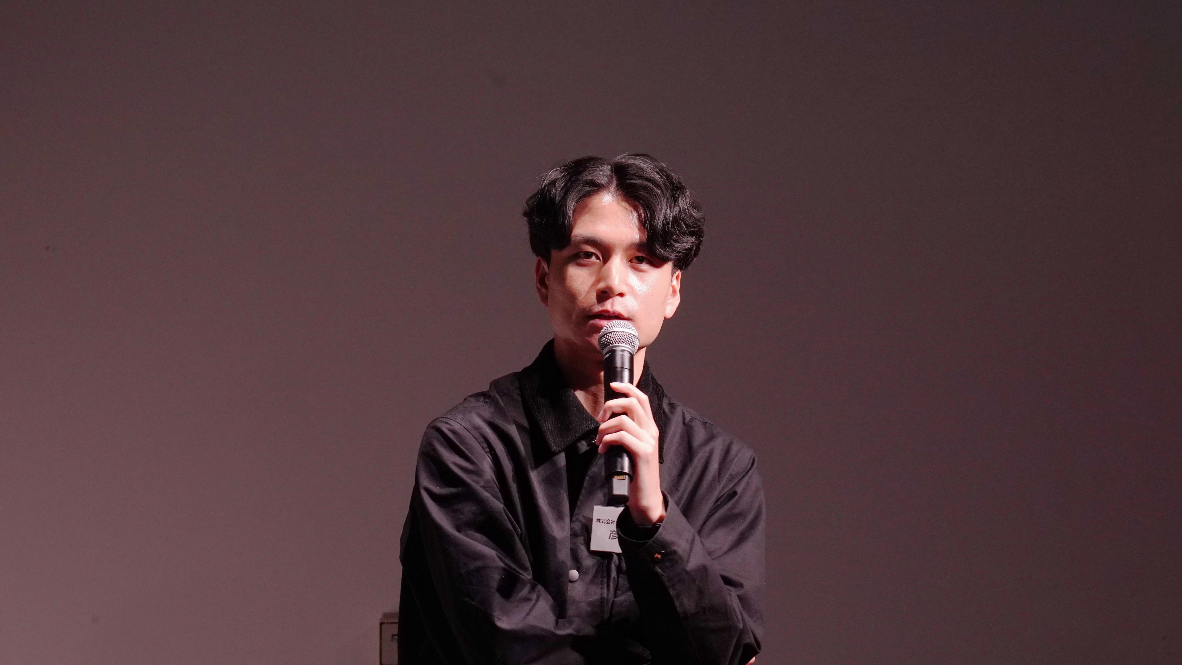 a young man is sitting in front of a microphone .