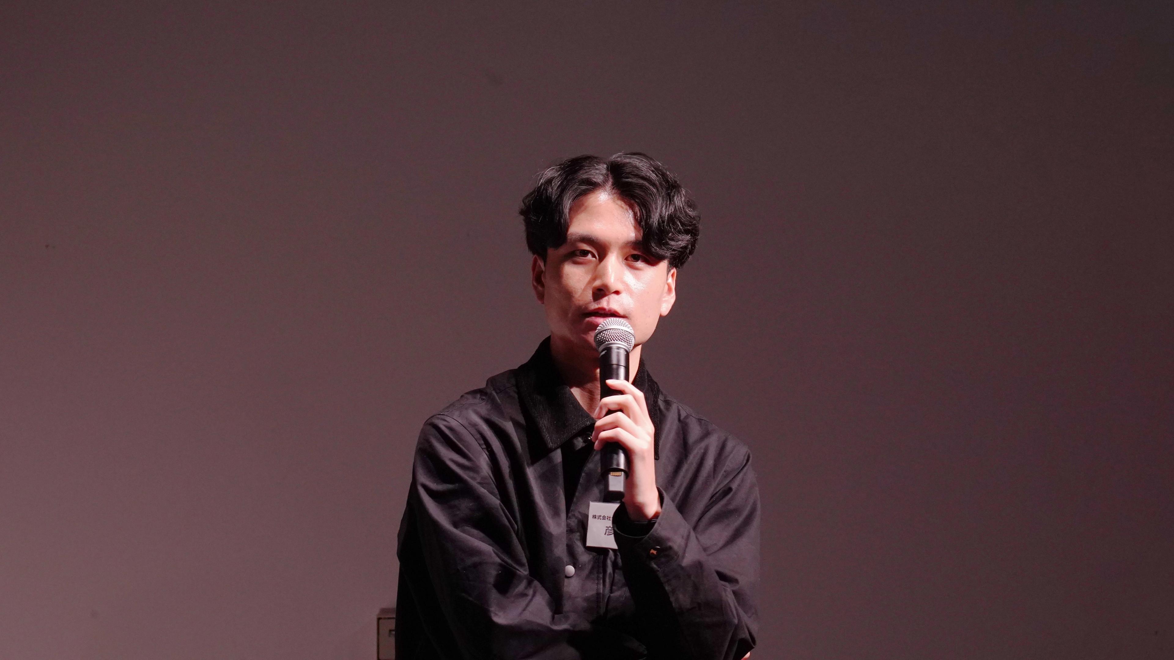 a young man is sitting in front of a microphone .