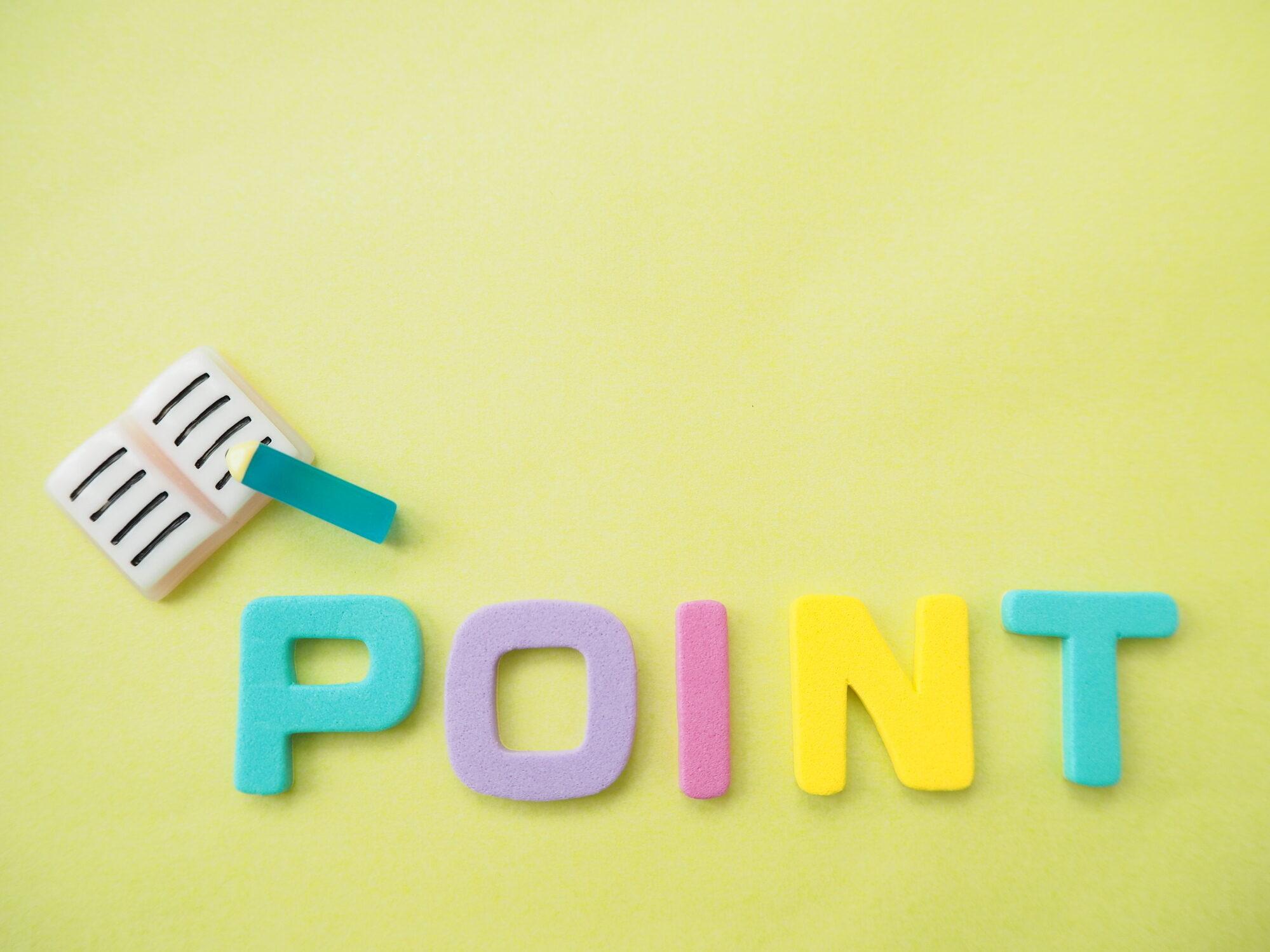 黄色い背景に「POINT」と書かれたカラフルな文字と、ノートのアイコンがあります。