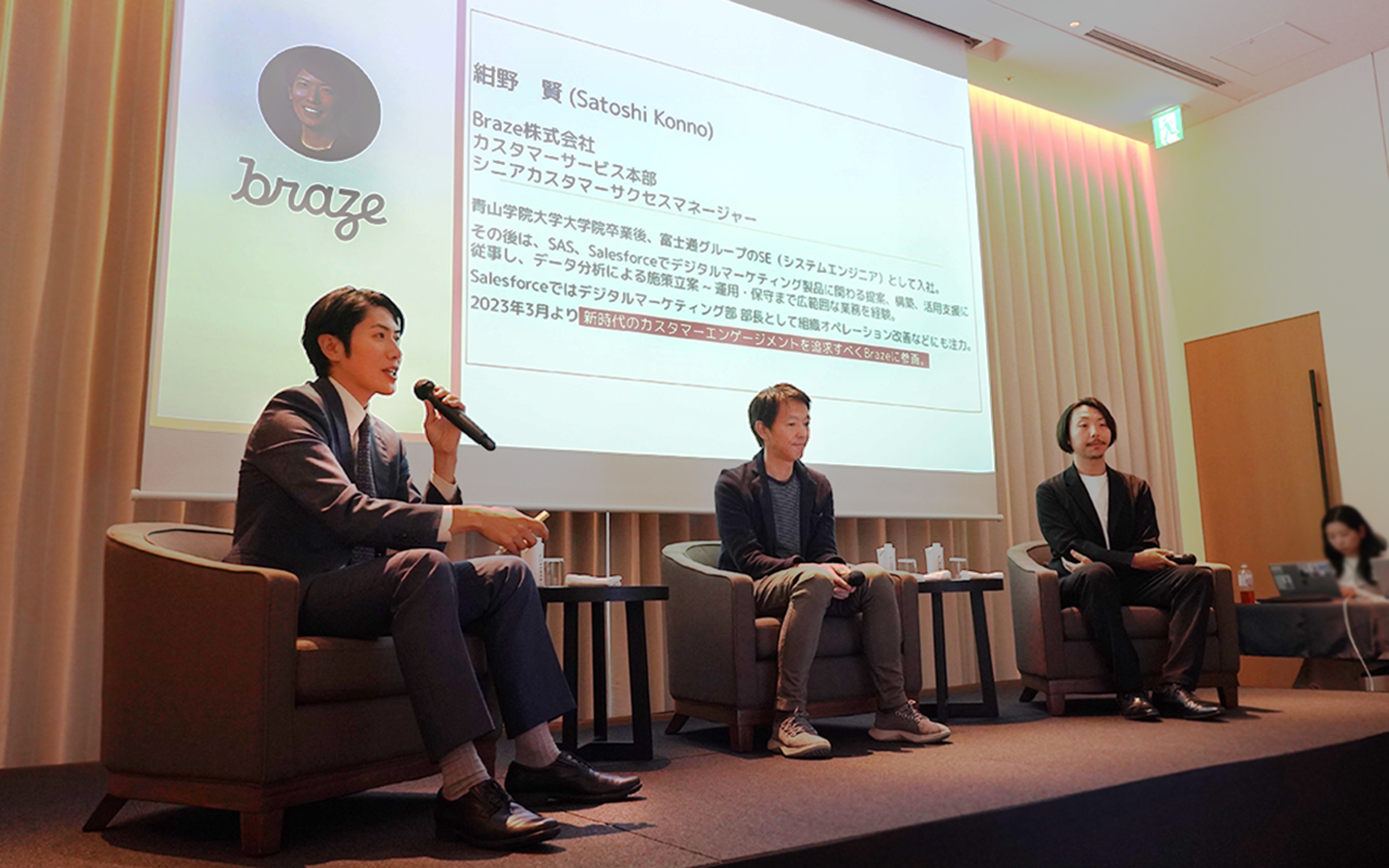 ブレイズ株式会社のカンファレンスで、3人のスピーカーがパネルディスカッションを行っています。背景にはプレゼンテーションが映し出されています。