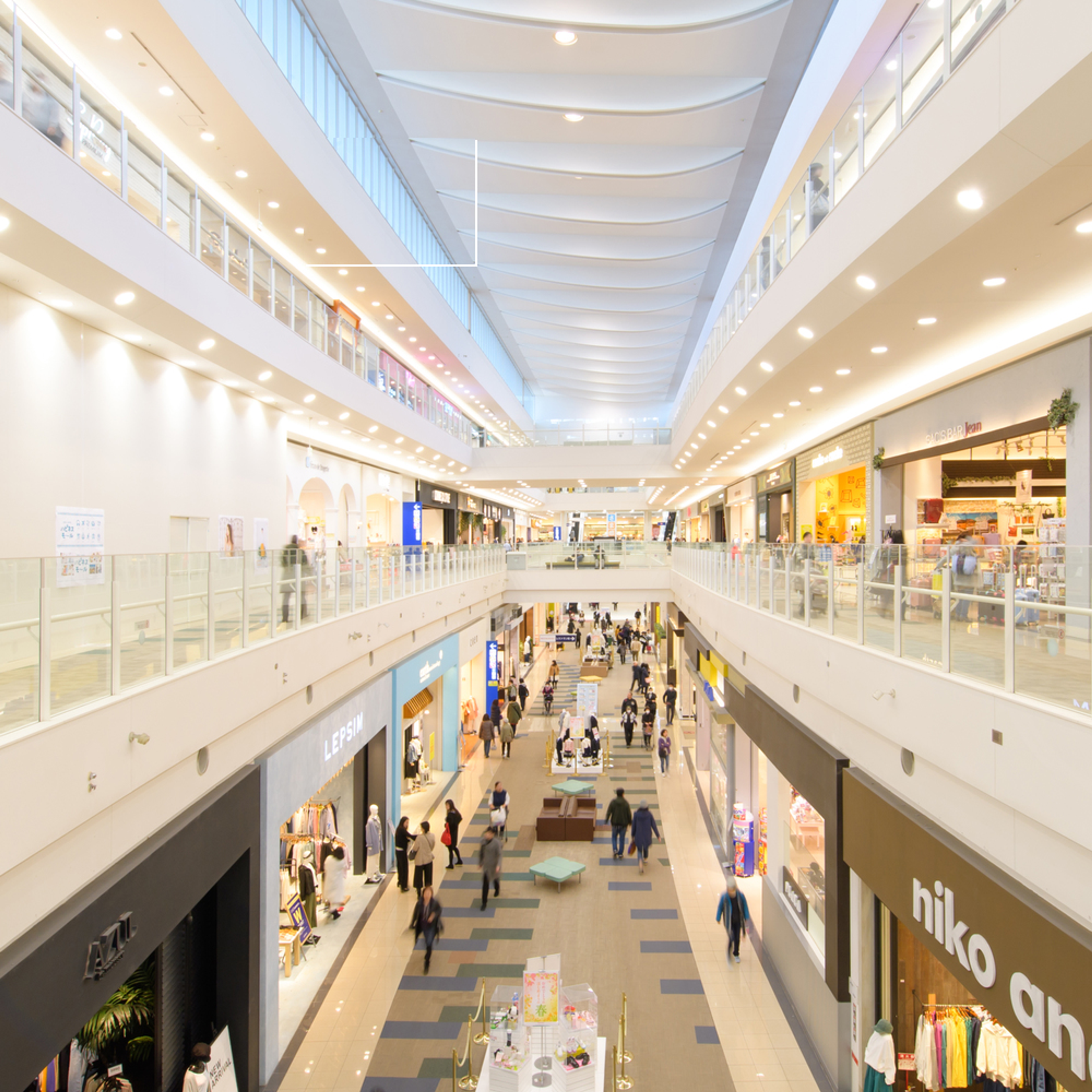 ショッピングモールの内部の風景。多くの人々が買い物を楽しんでいる様子が見られます。